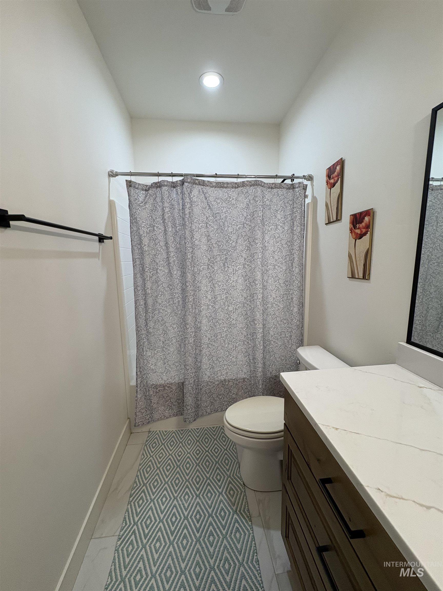 Full bathroom featuring shower / bathtub combination with curtain and vanity