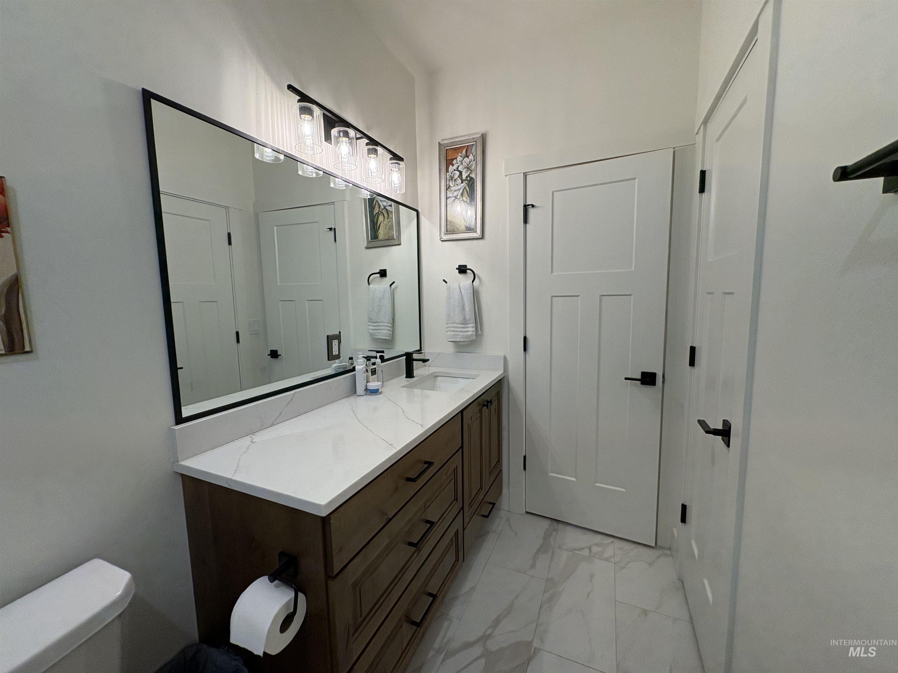 Bathroom with vanity and light marble finish floors