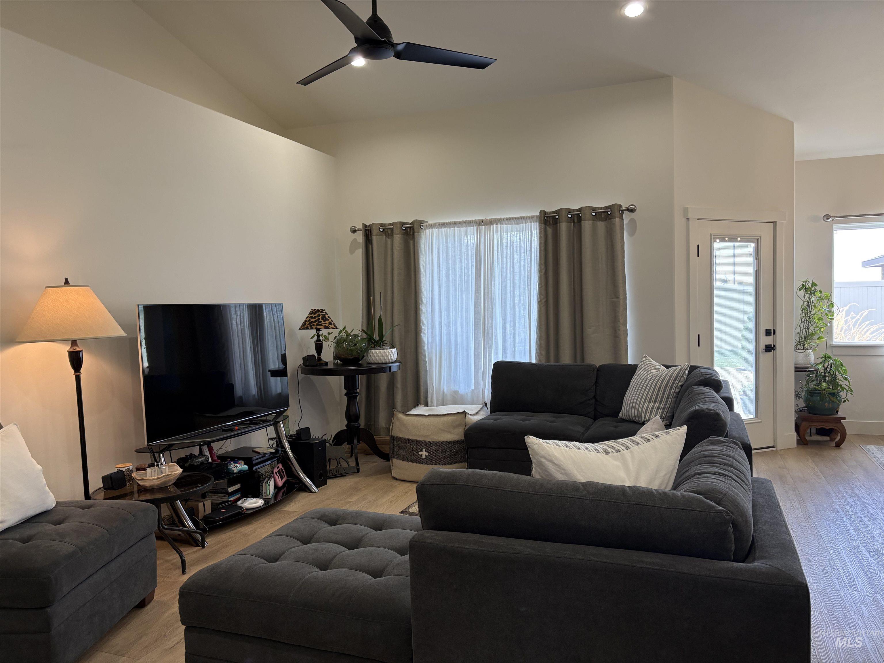 Living area with recessed lighting, ceiling fan, light wood-style floors, and vaulted ceiling