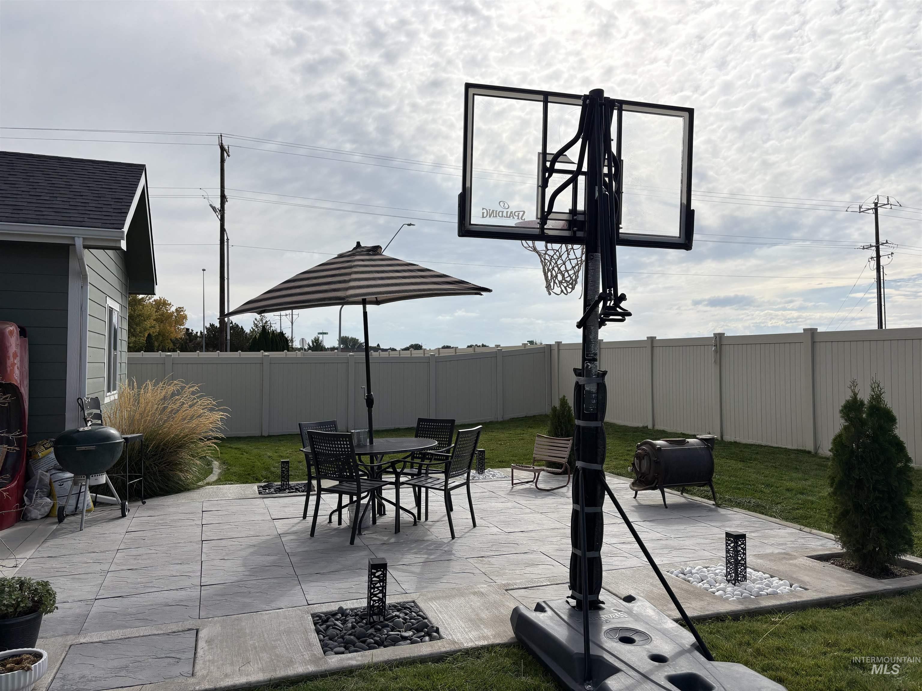 Fenced backyard featuring a patio area, a grill, and outdoor dining area