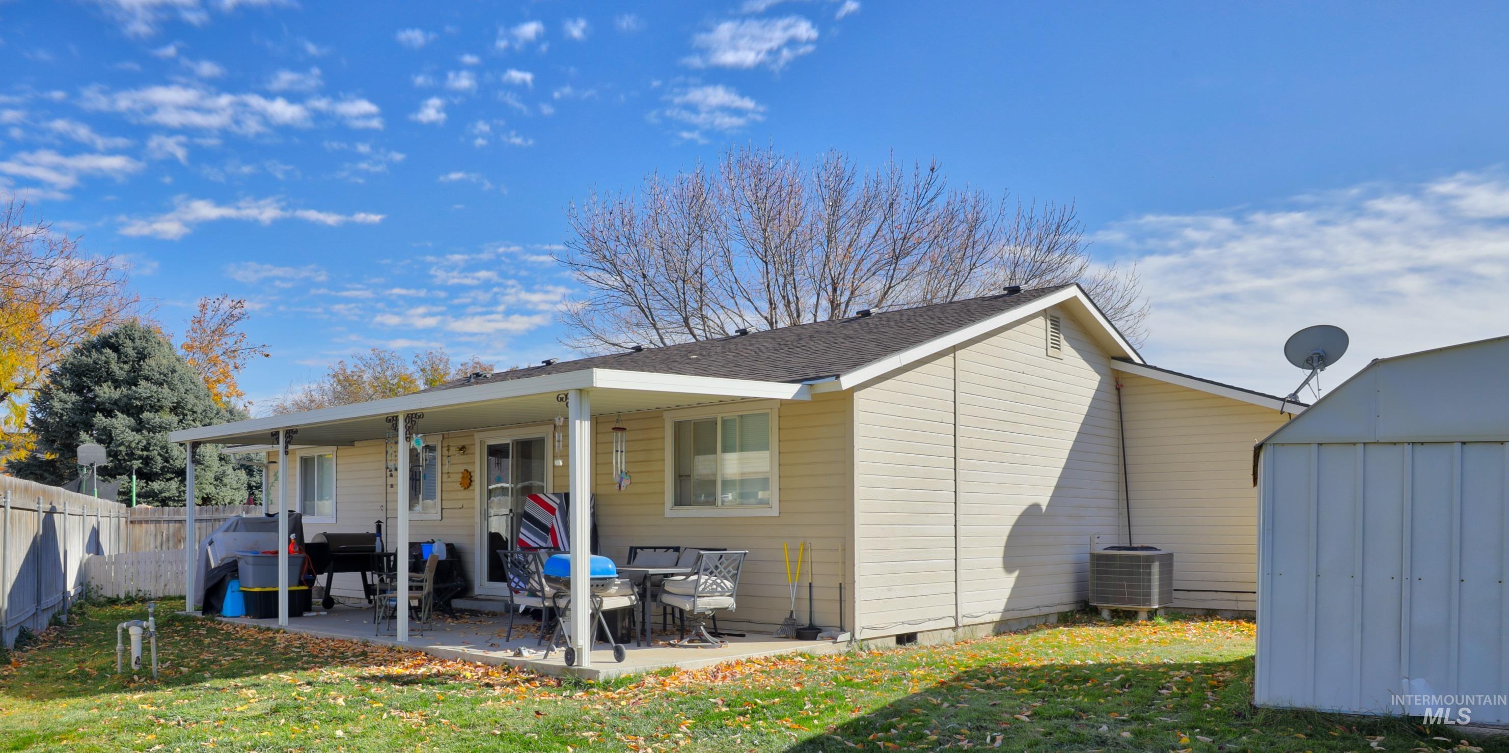 Back of property featuring a patio, crawl space, a shed, and roof with shingles