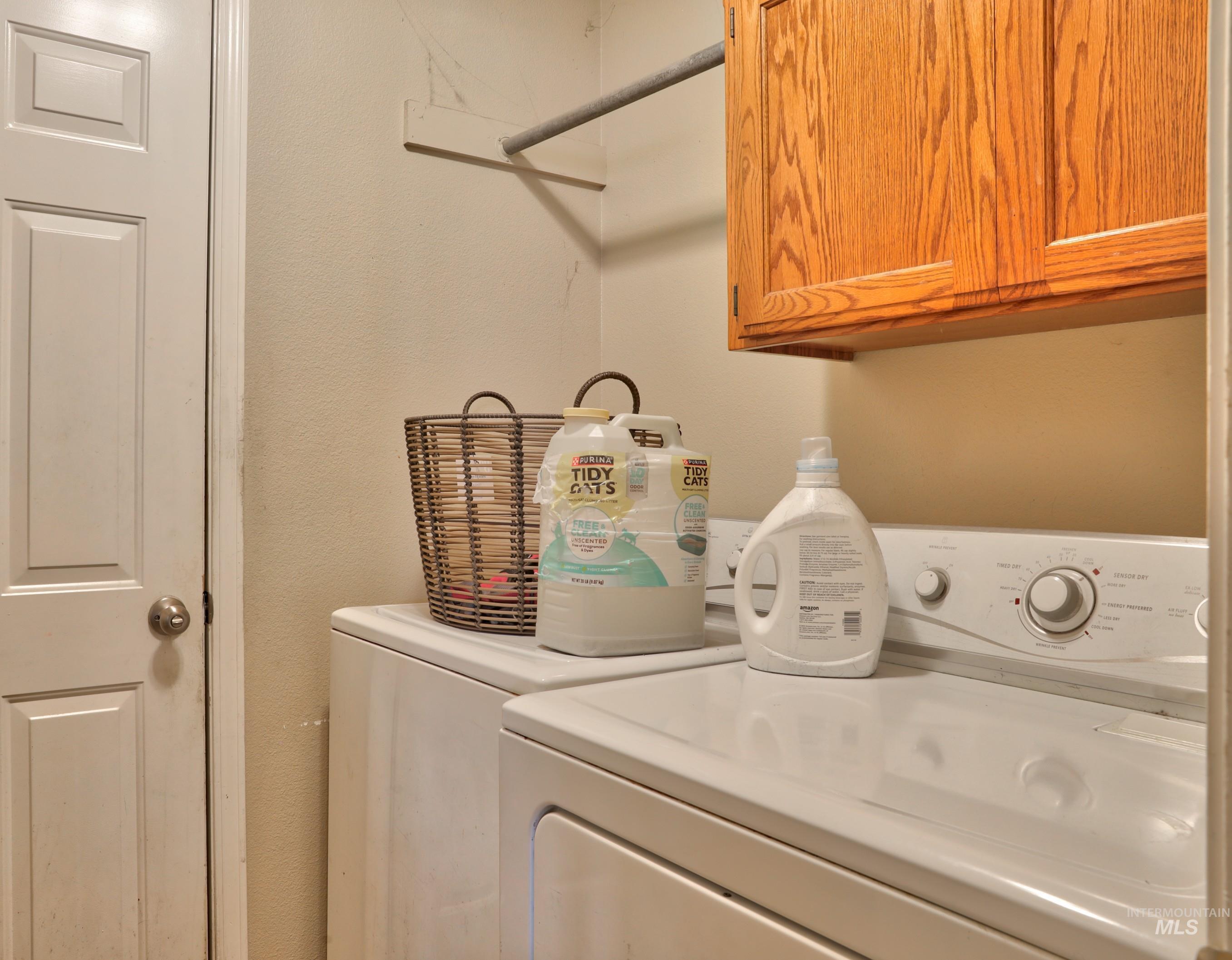 Washroom featuring cabinet space and separate washer and dryer