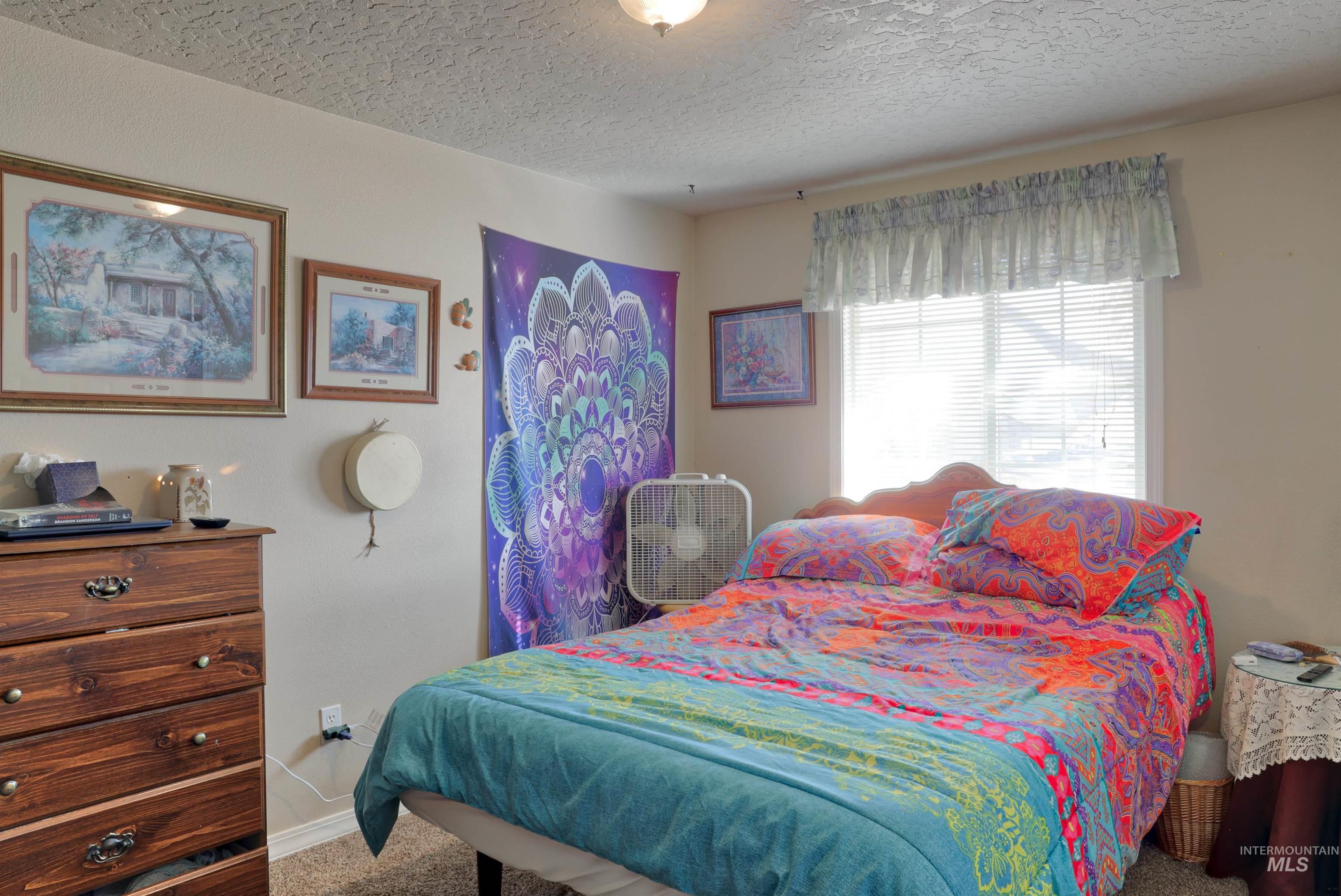 Bedroom with carpet floors and a textured ceiling