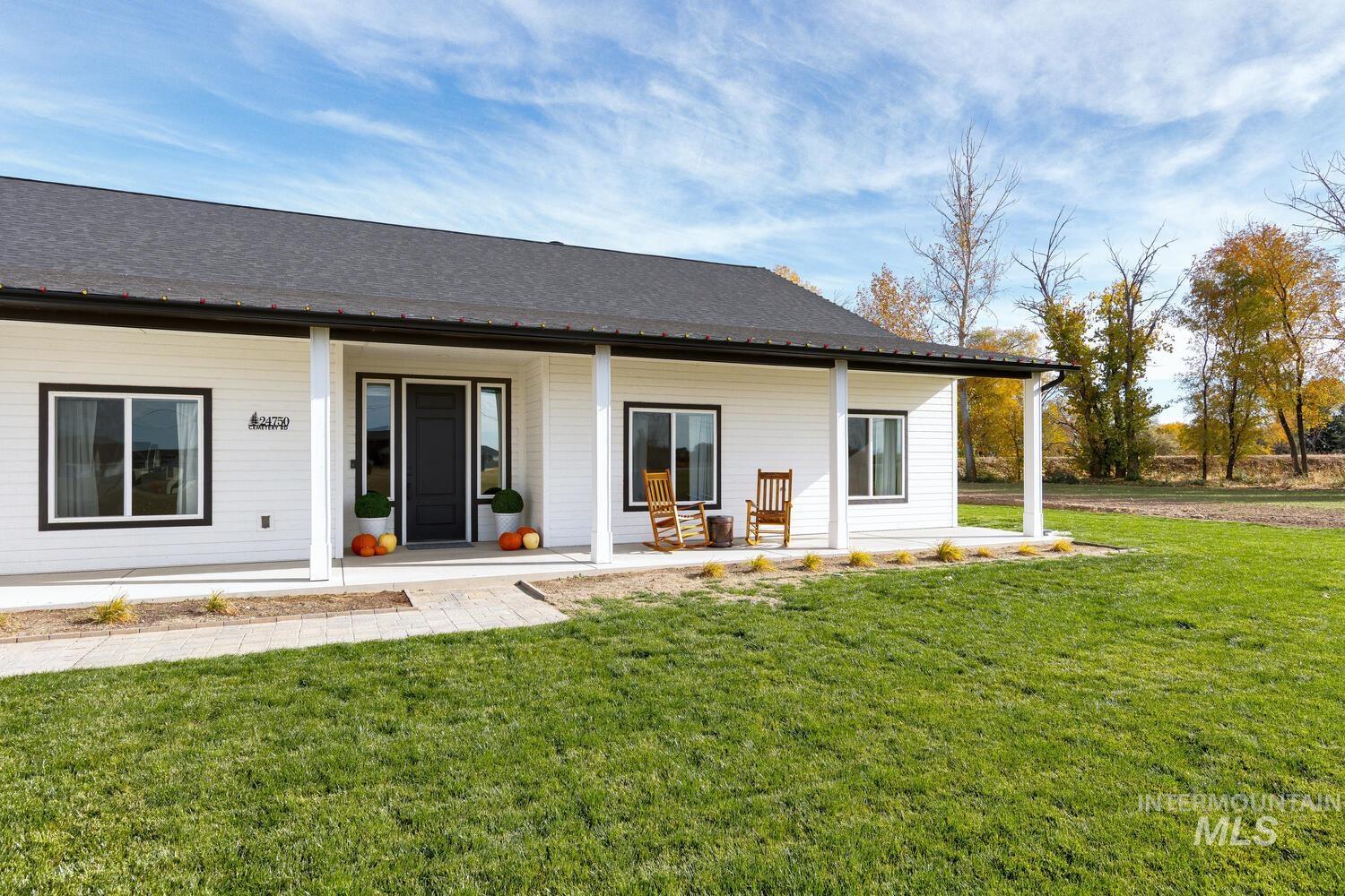Rear view of house featuring a porch, a lawn, and a shingled roof