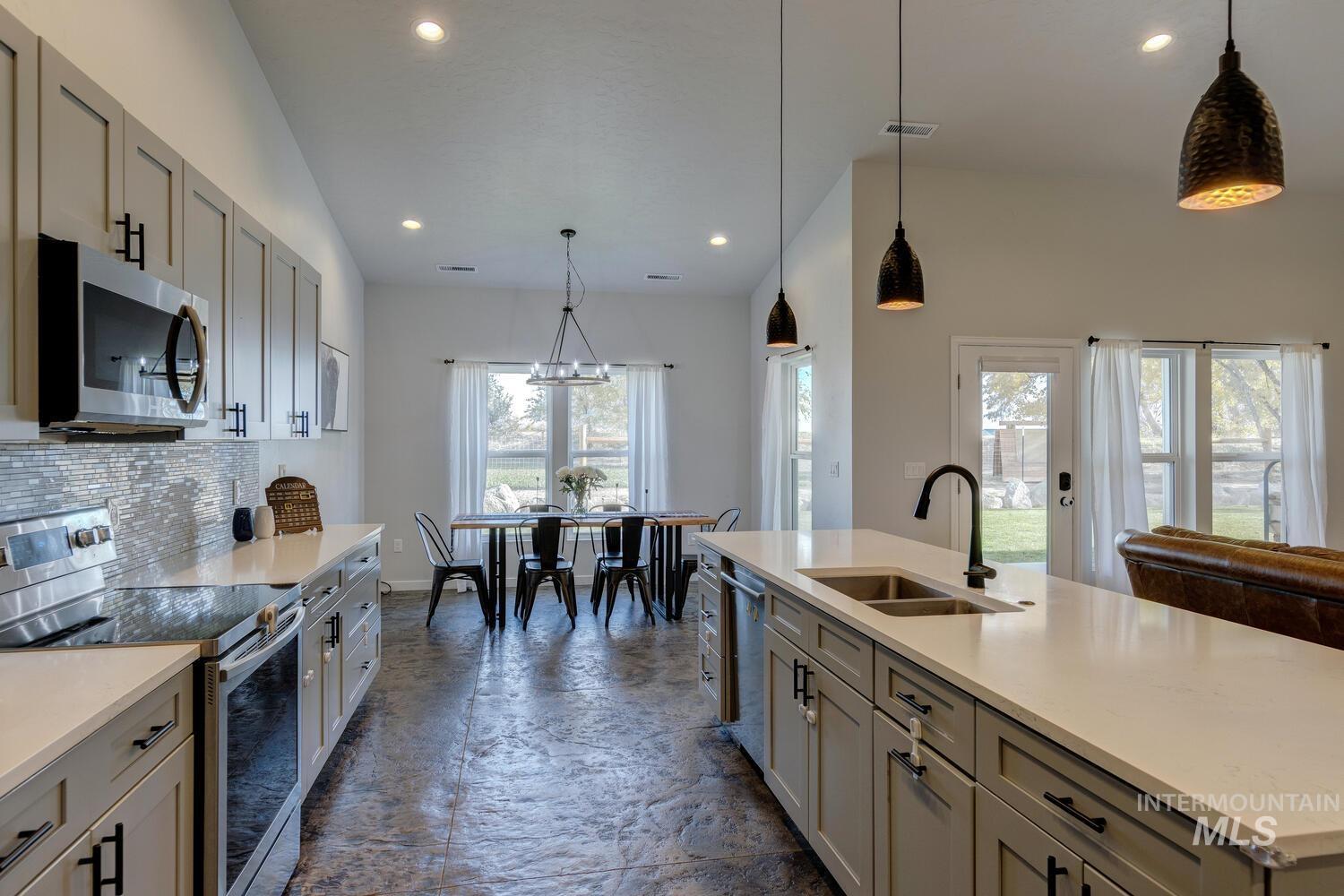 Kitchen featuring gray cabinetry, stainless steel appliances, pendant lighting, and recessed lighting