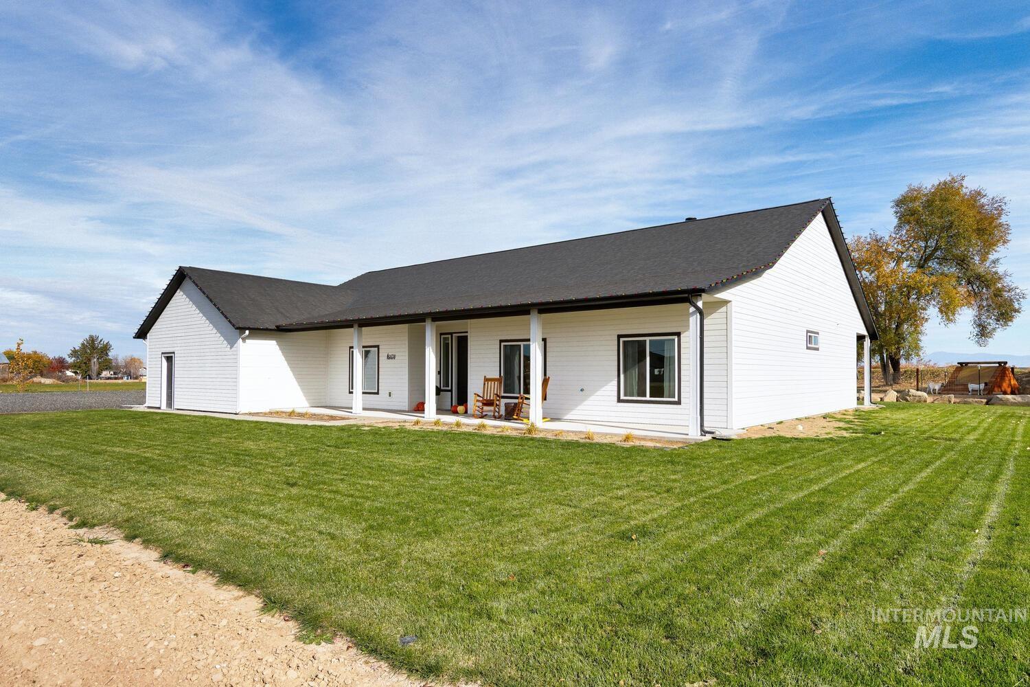 Rear view of property with a lawn and covered porch