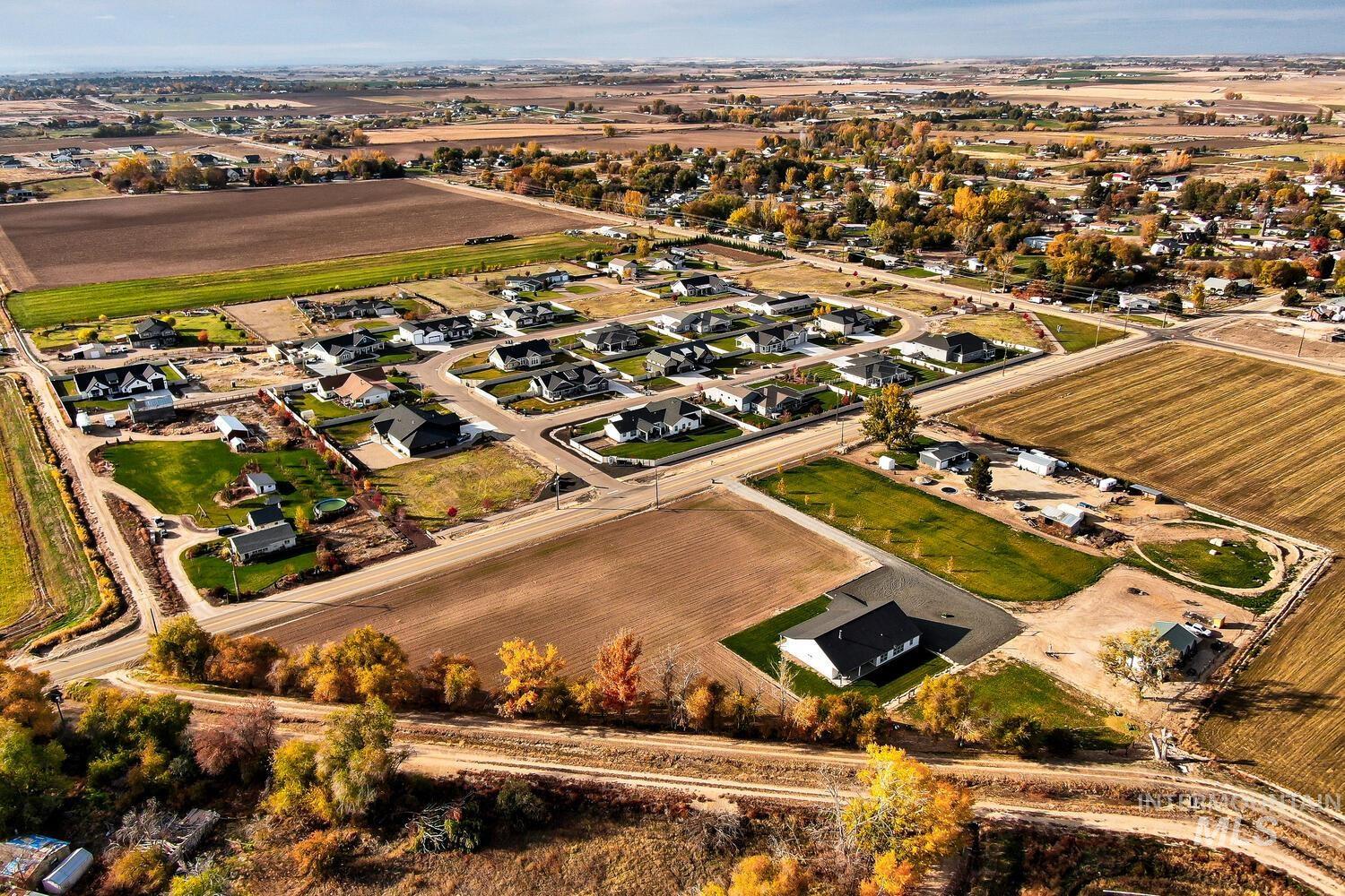 View of property location with rural landscape, large plots for crops, and nearby suburban area