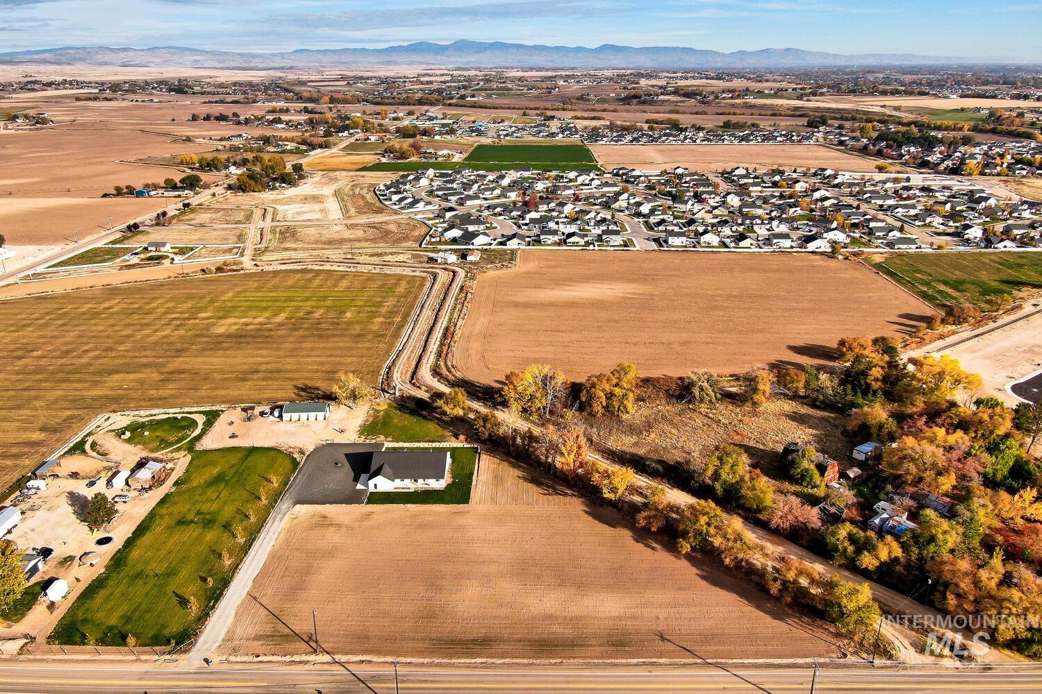Aerial overview of property's location with rural landscape, a mountain backdrop, and abundant farmland