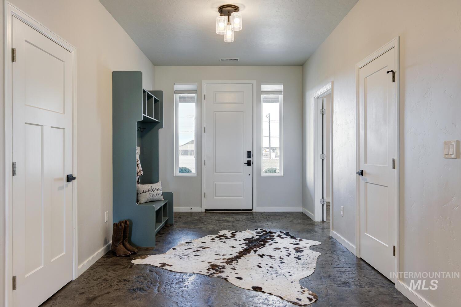 Foyer with baseboards and concrete flooring