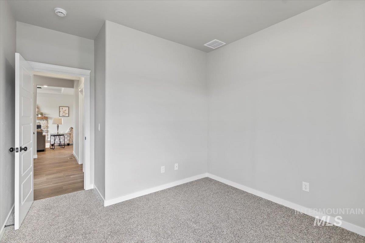 Empty room with carpet and baseboards