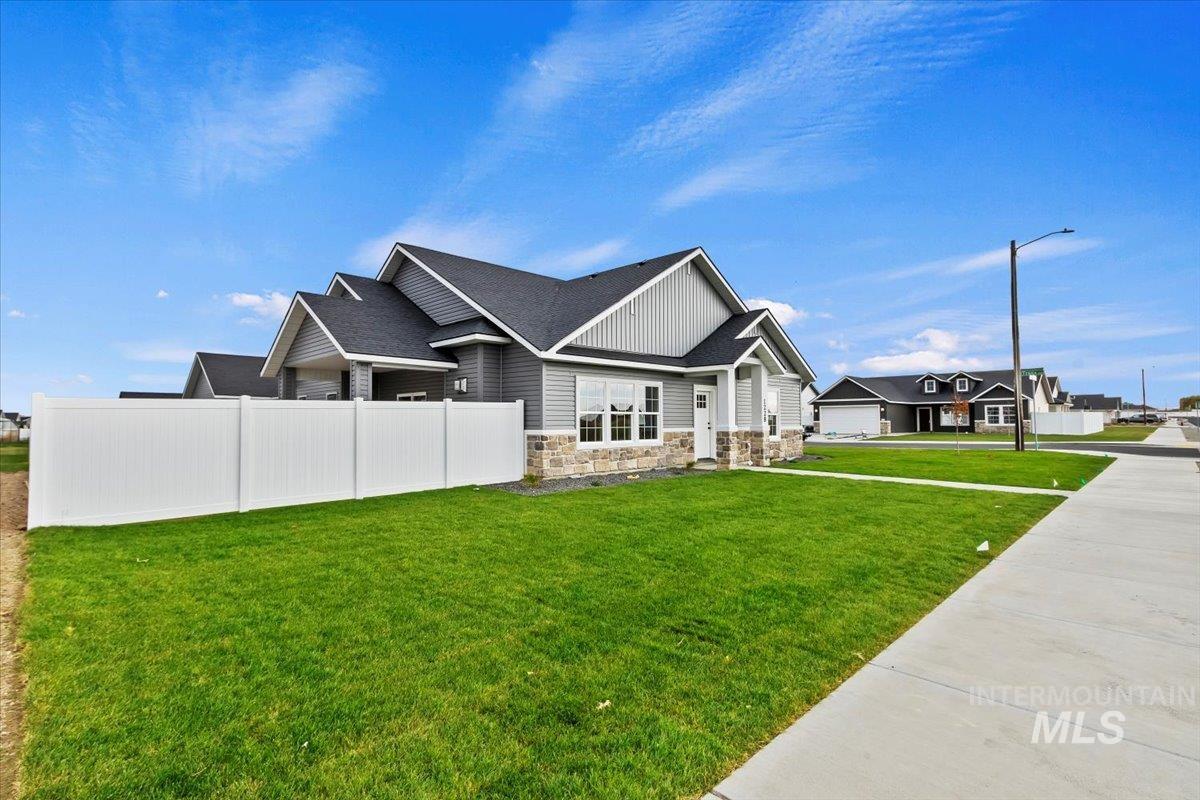 View of home's exterior with stone siding and roof with shingles
