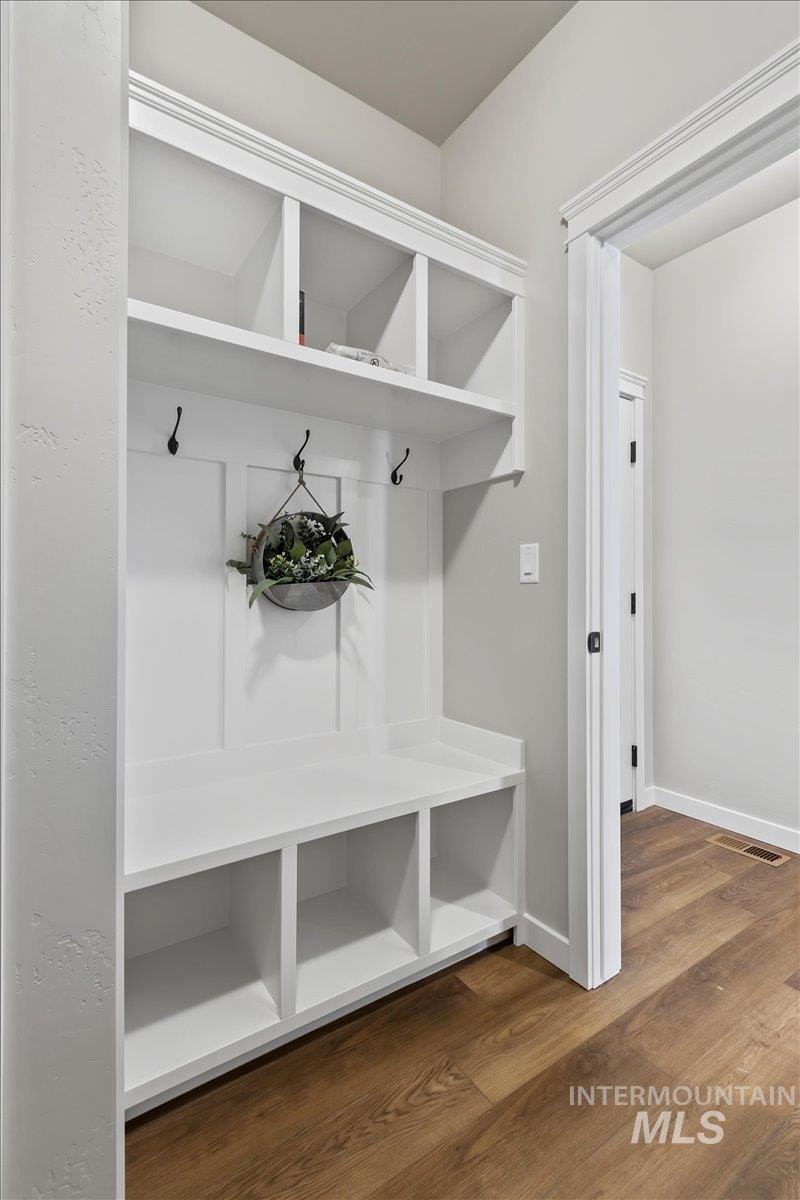 Mudroom featuring dark wood-type flooring and baseboards