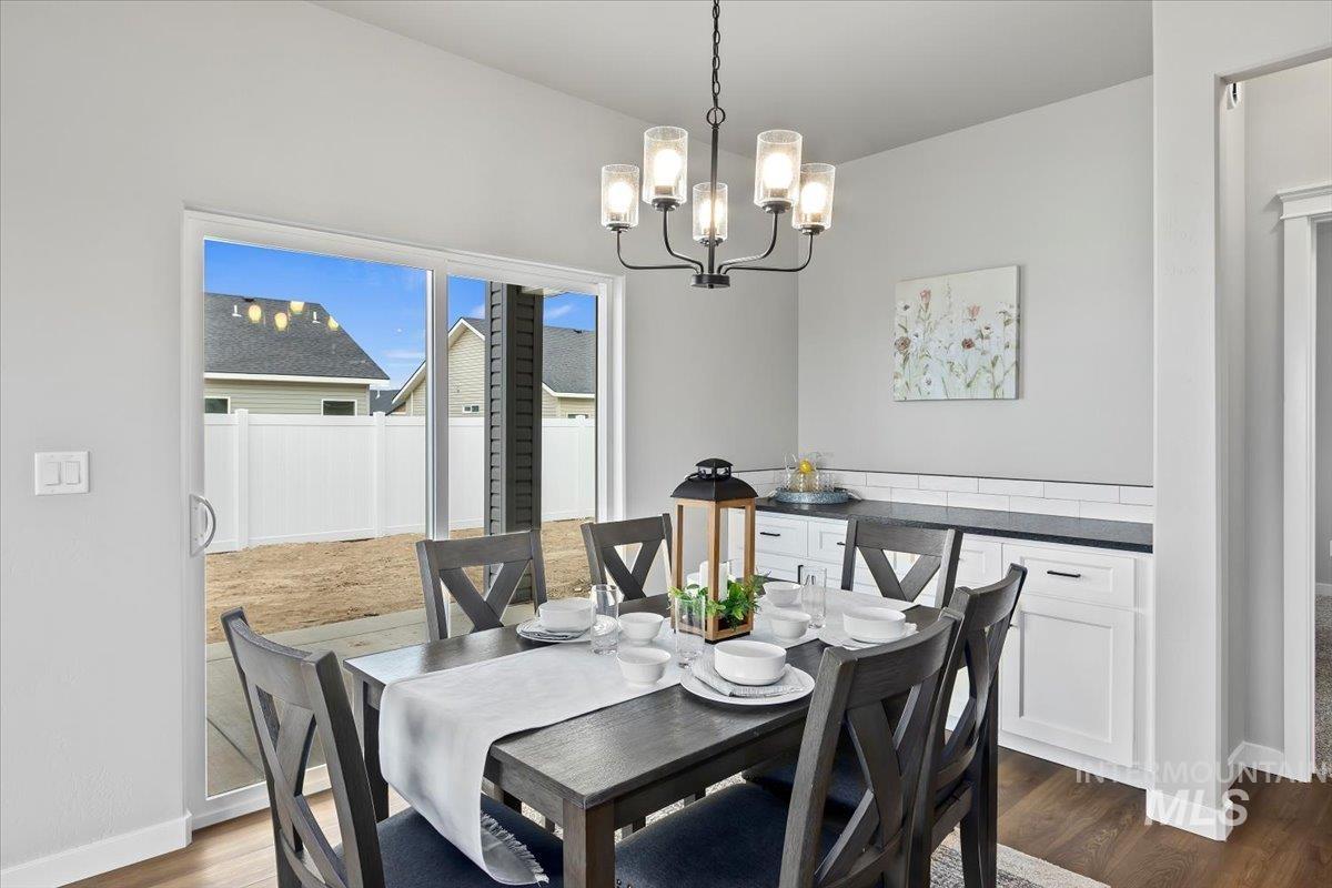 Dining room featuring dark wood finished floors and a chandelier