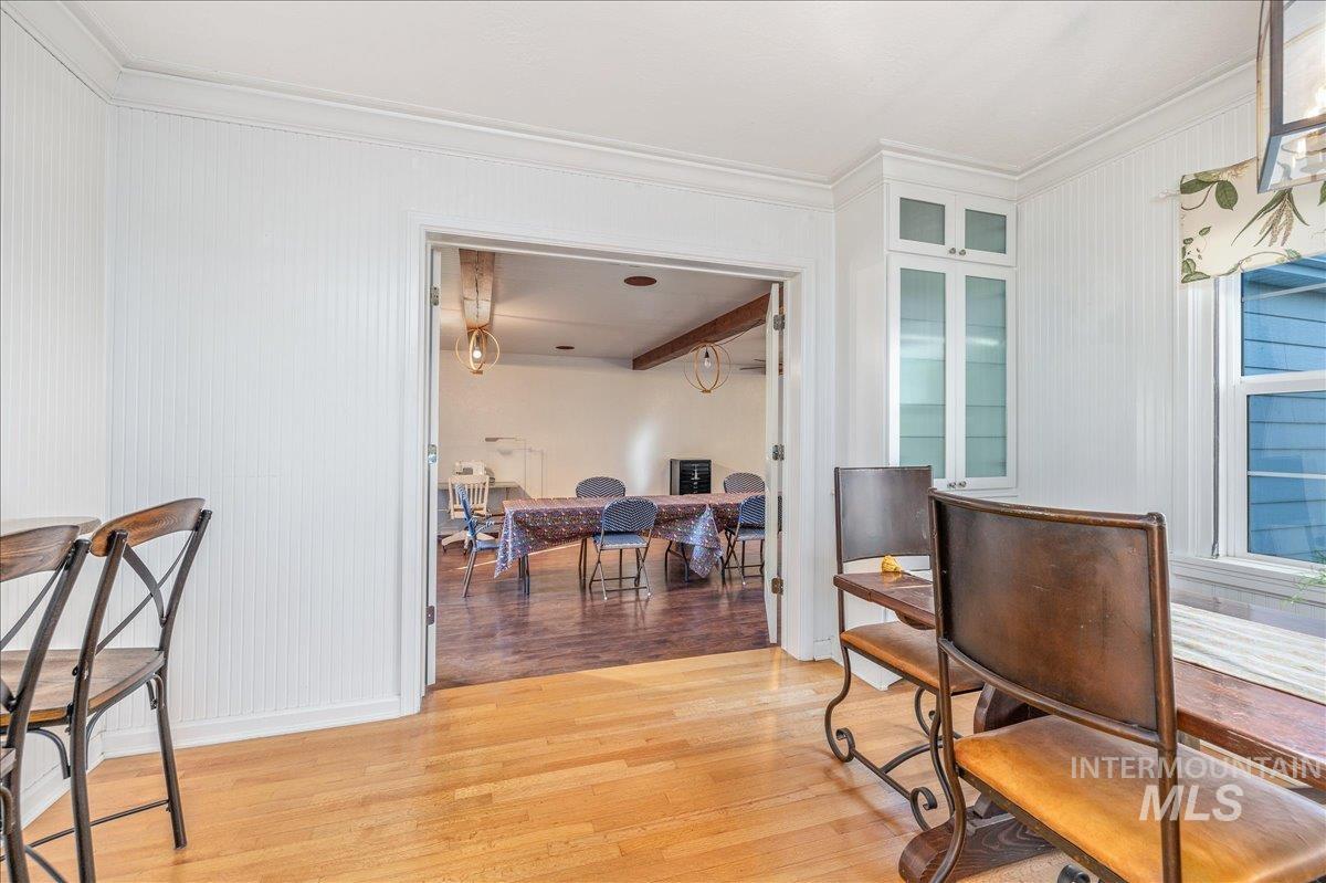 Living area with light wood-style floors and ornamental molding