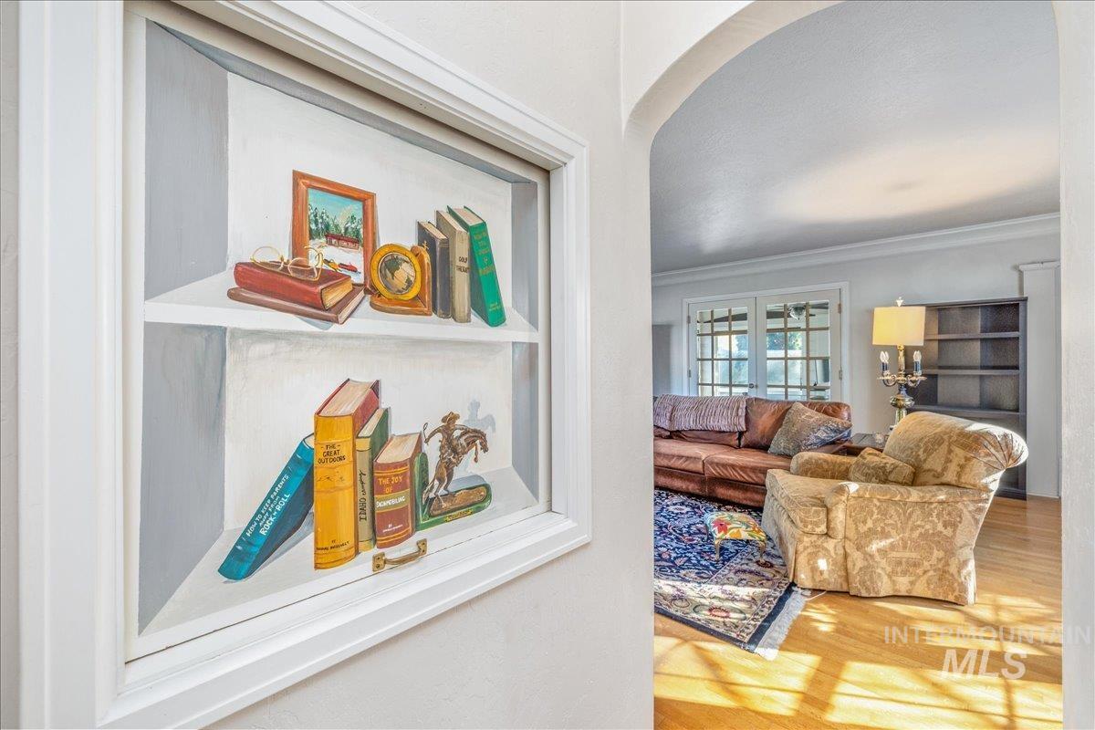Hallway featuring crown molding, arched walkways, and wood finished floors