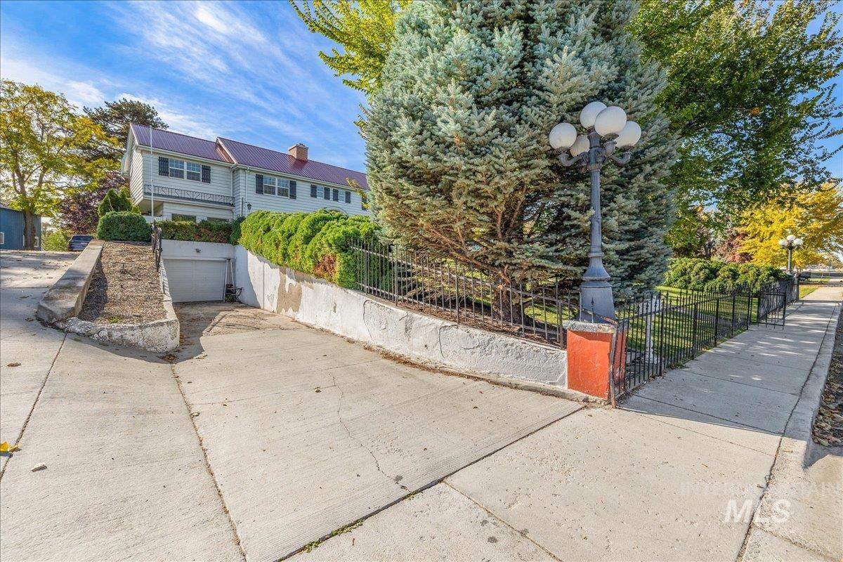 View of front of property featuring a fenced front yard, an attached garage, concrete driveway, and a chimney