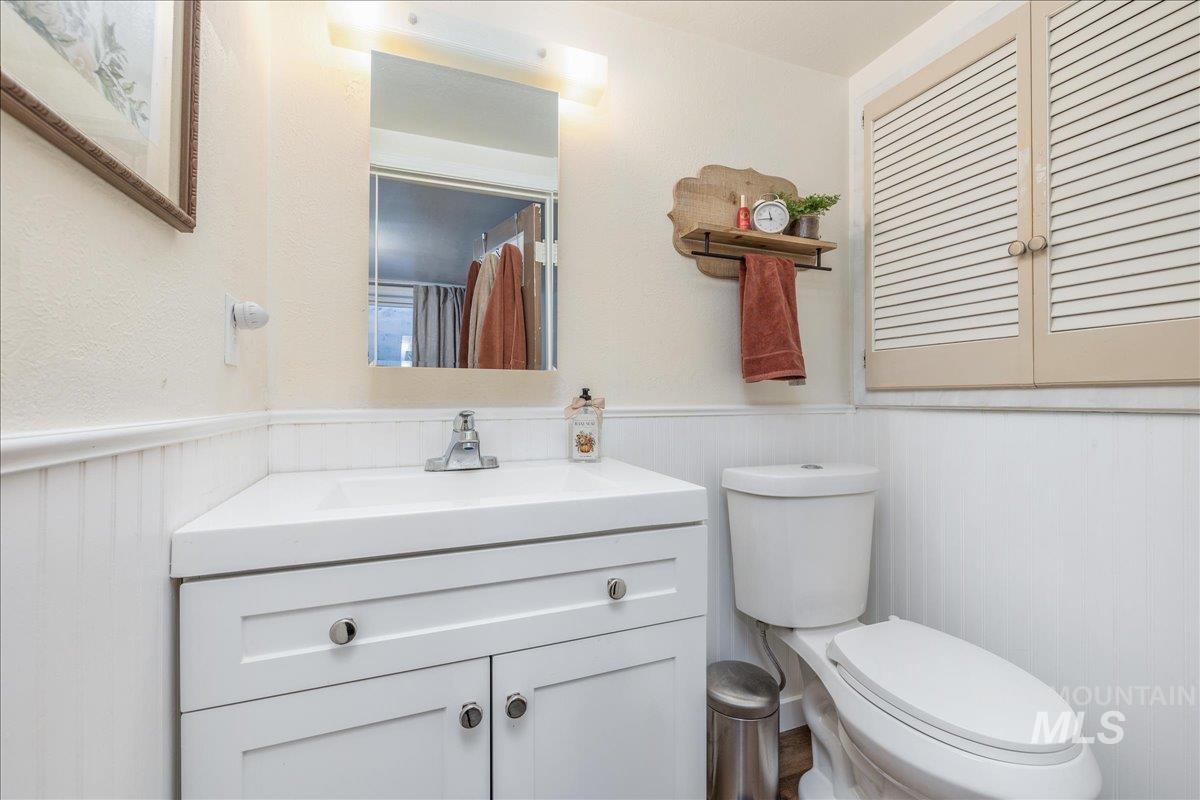 Half bathroom featuring vanity and wainscoting