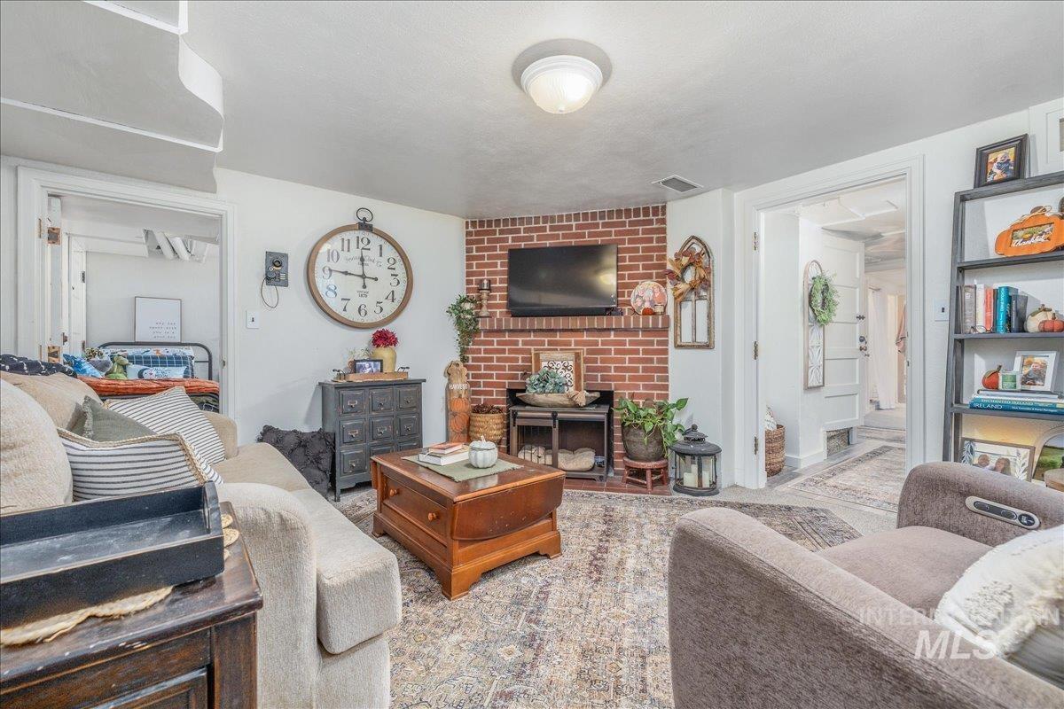 Living room featuring a brick fireplace and carpet flooring
