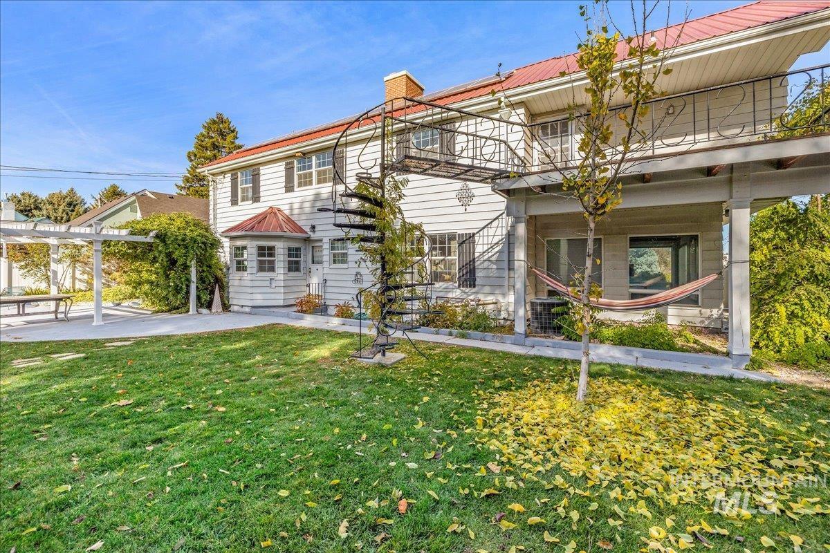 View of front of property featuring a front yard, a chimney, and stairs
