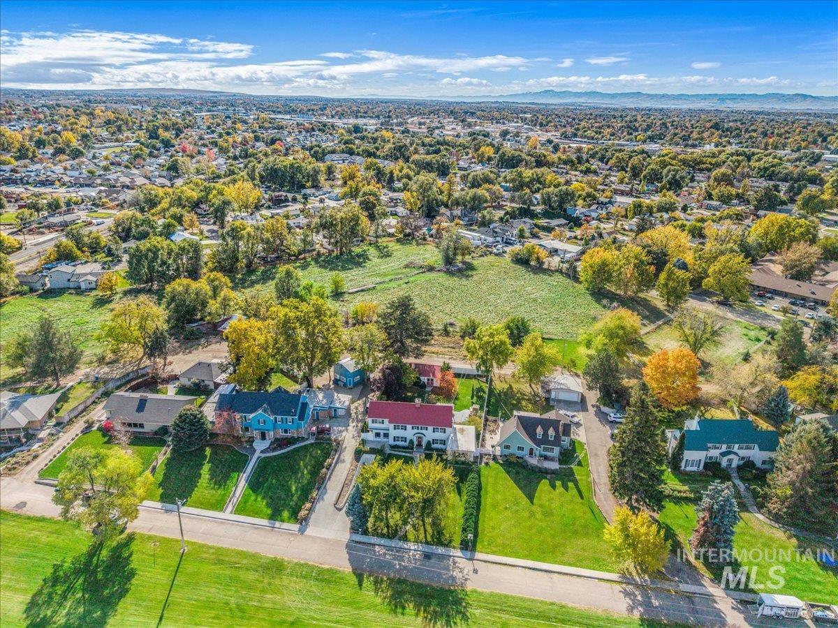 Aerial view of property's location with nearby suburban area and a mountainous background