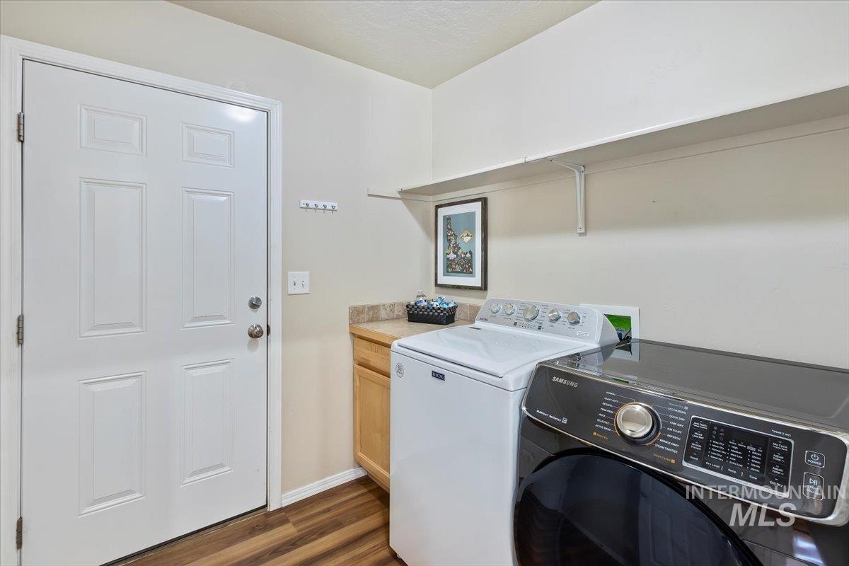 Laundry room with dark wood-type flooring and independent washer and dryer