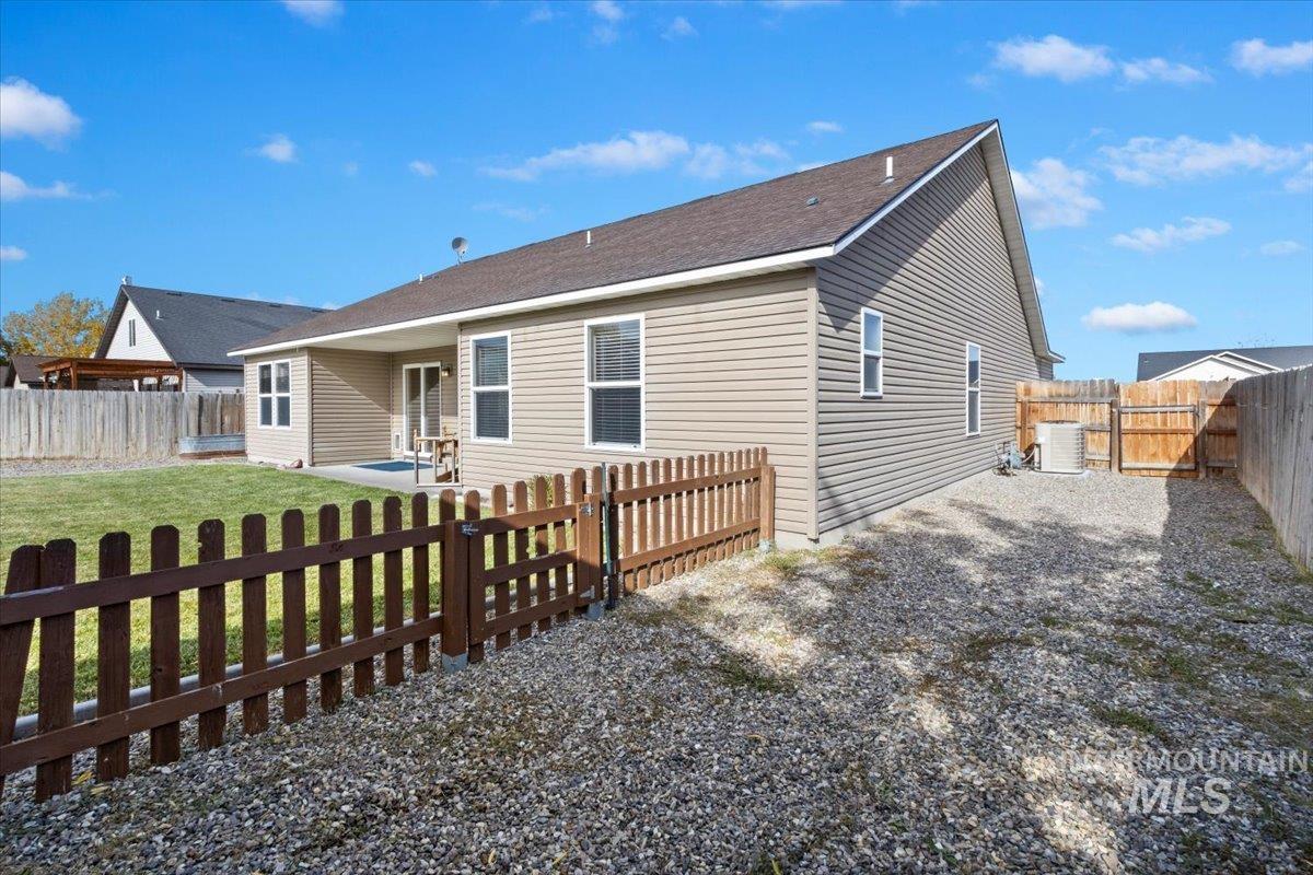 Back of house with a patio area, a fenced backyard, and a gate