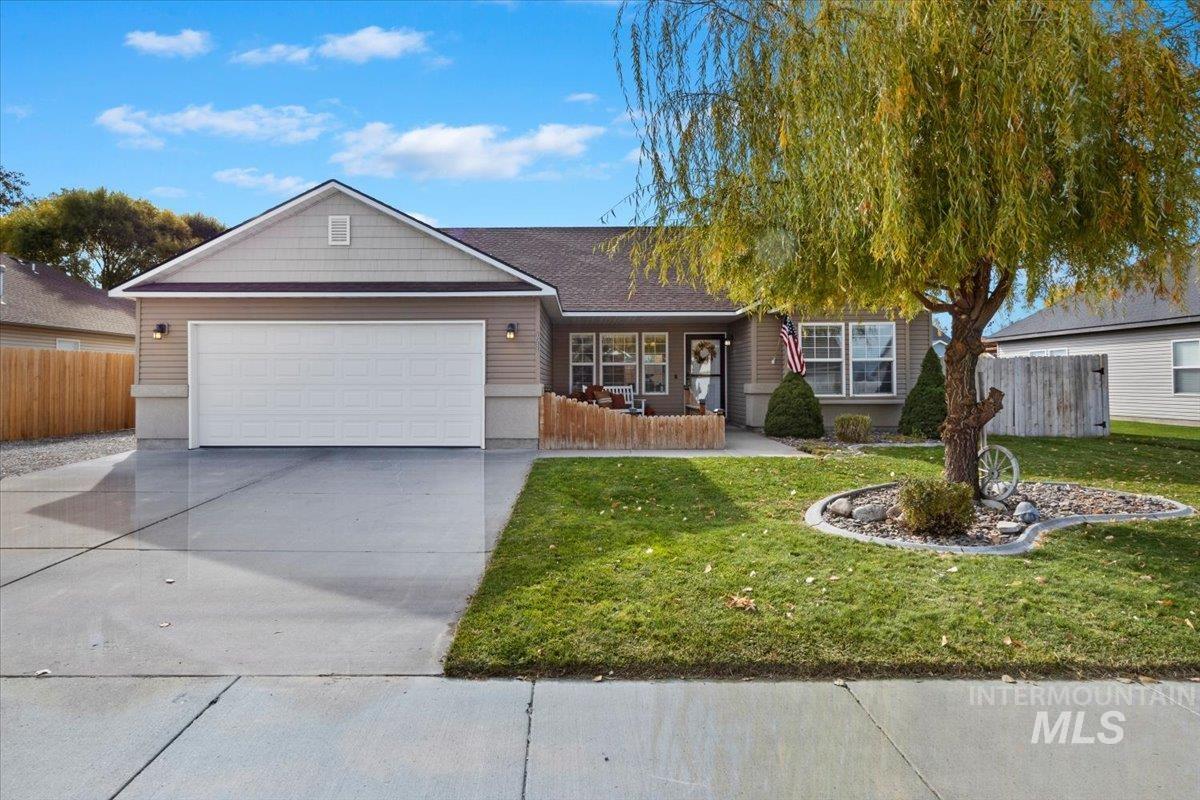 Ranch-style house featuring a porch, driveway, and a garage