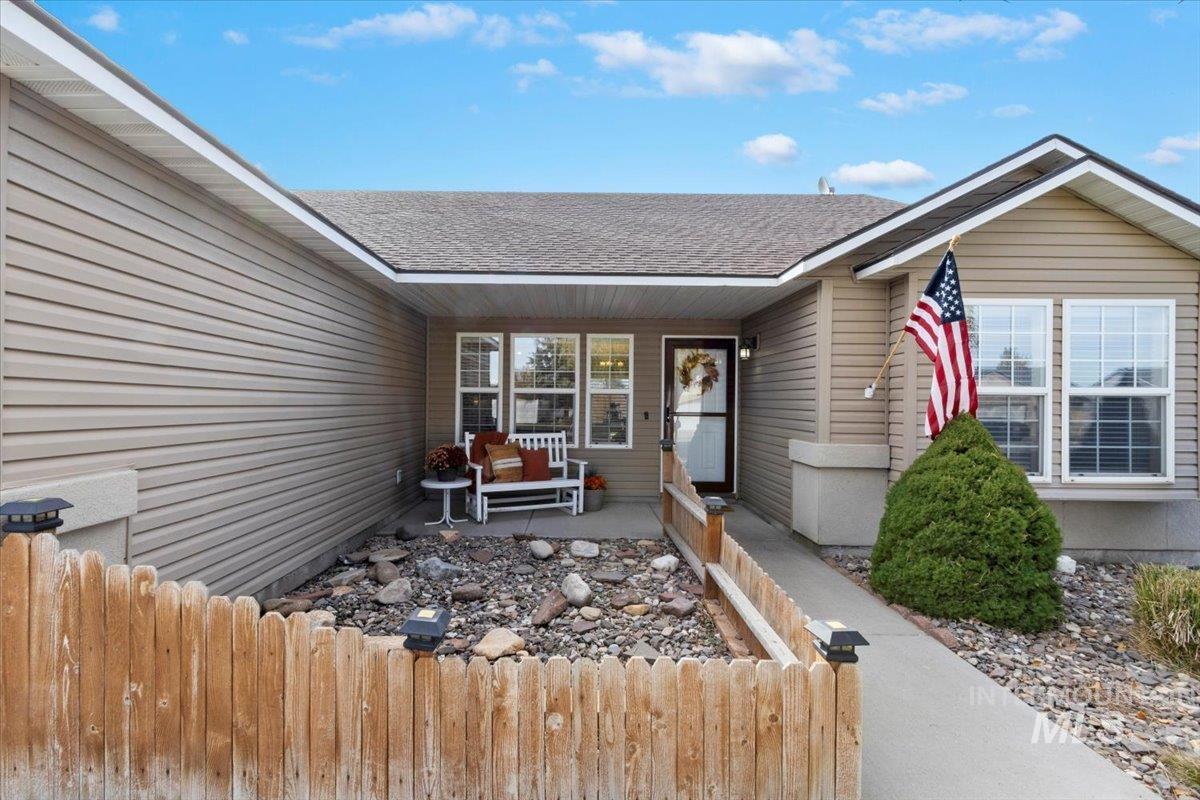 Property entrance featuring roof with shingles and a porch