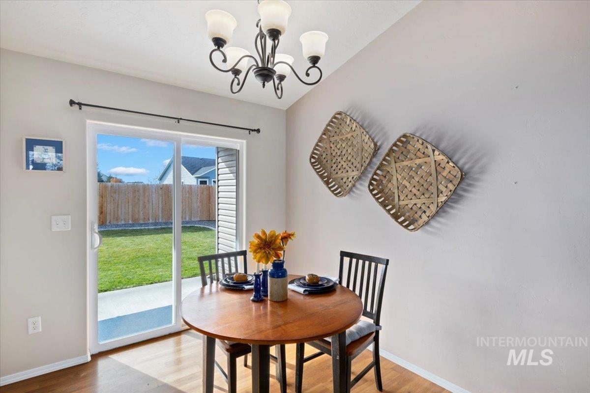 Dining space with wood finished floors and a chandelier