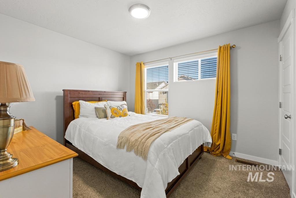 Bedroom with dark carpet and baseboards