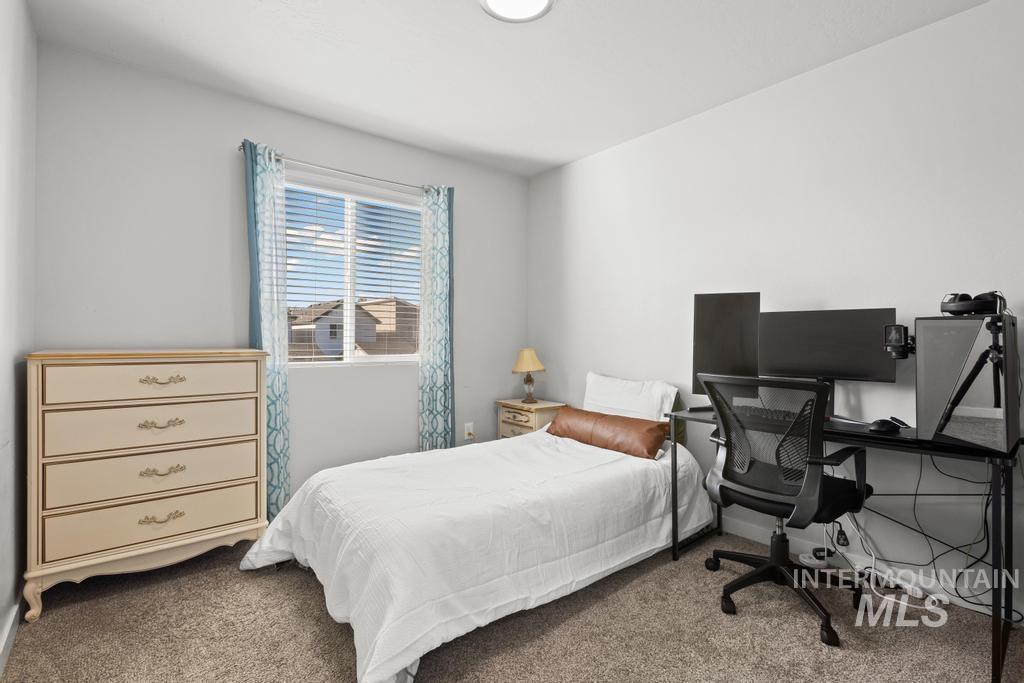 Carpeted bedroom featuring a desk