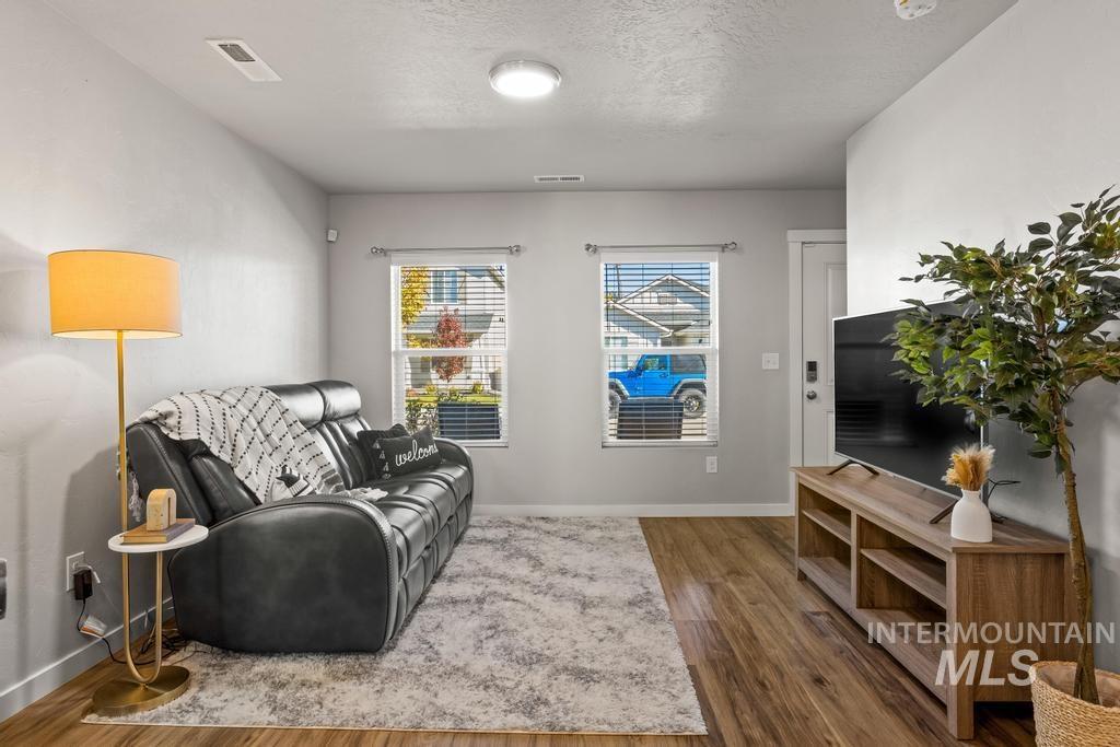 Living area with a textured ceiling and wood finished floors