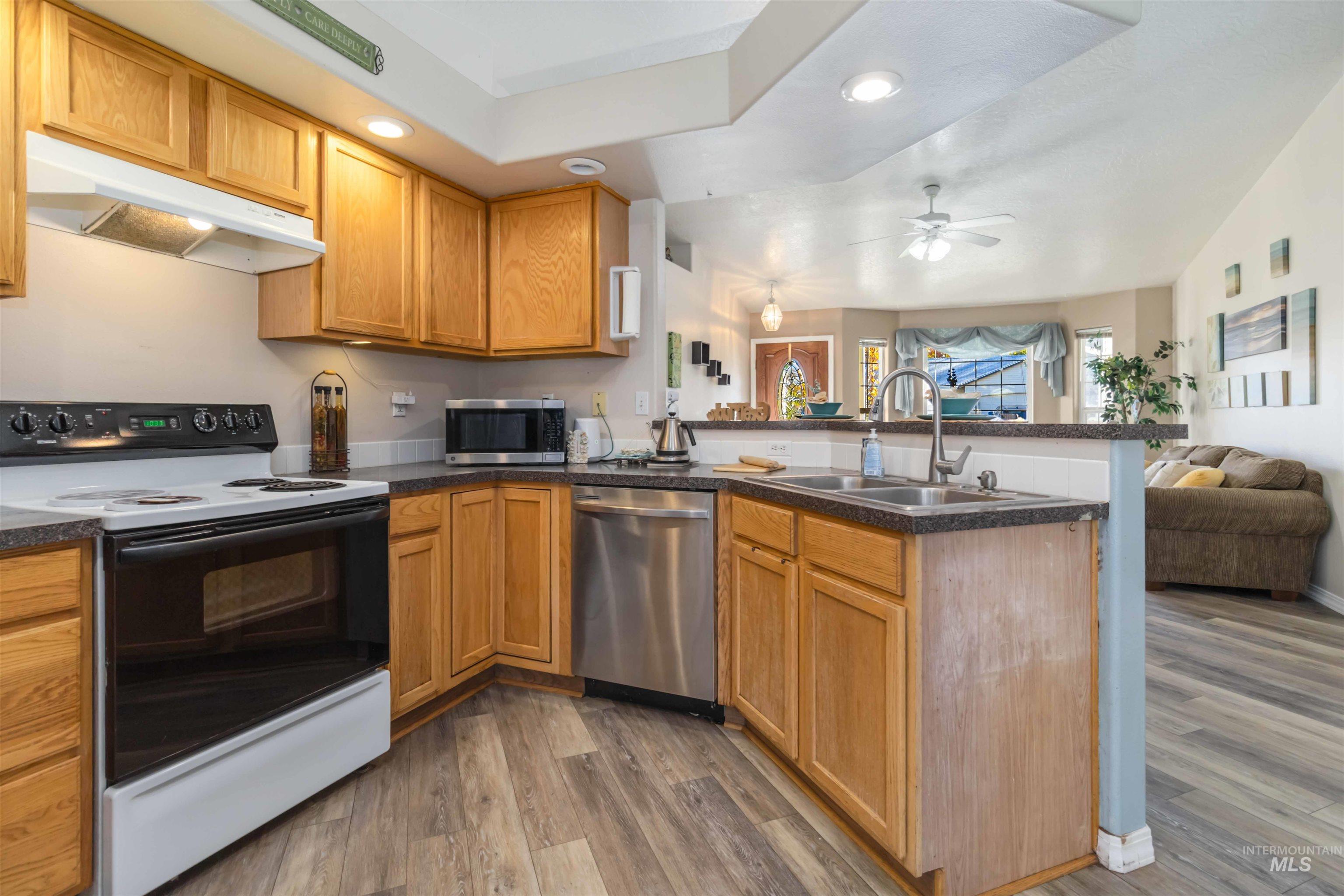 Kitchen with open floor plan, stainless steel appliances, a peninsula, recessed lighting, and under cabinet range hood