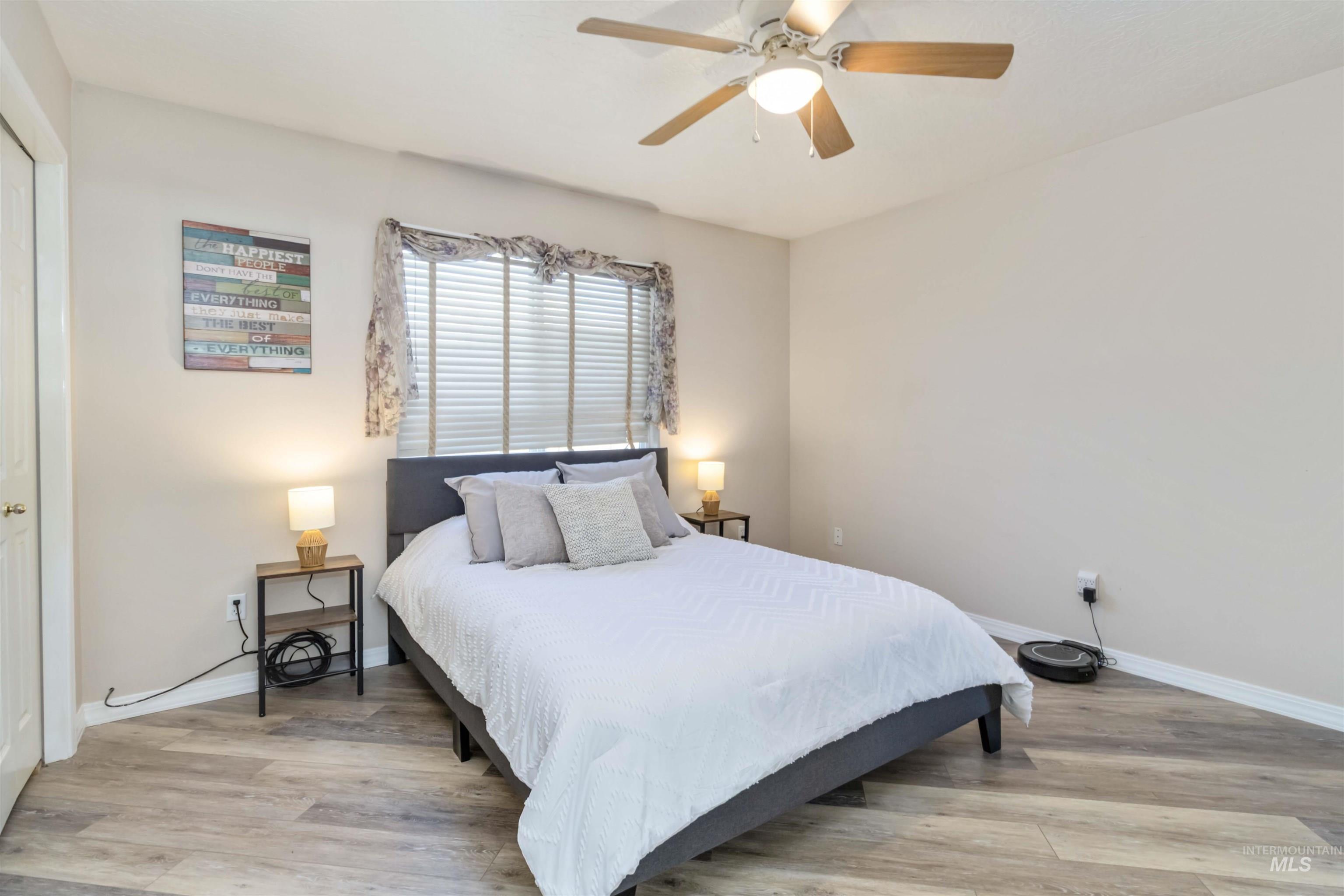 Bedroom with light wood finished floors and a ceiling fan