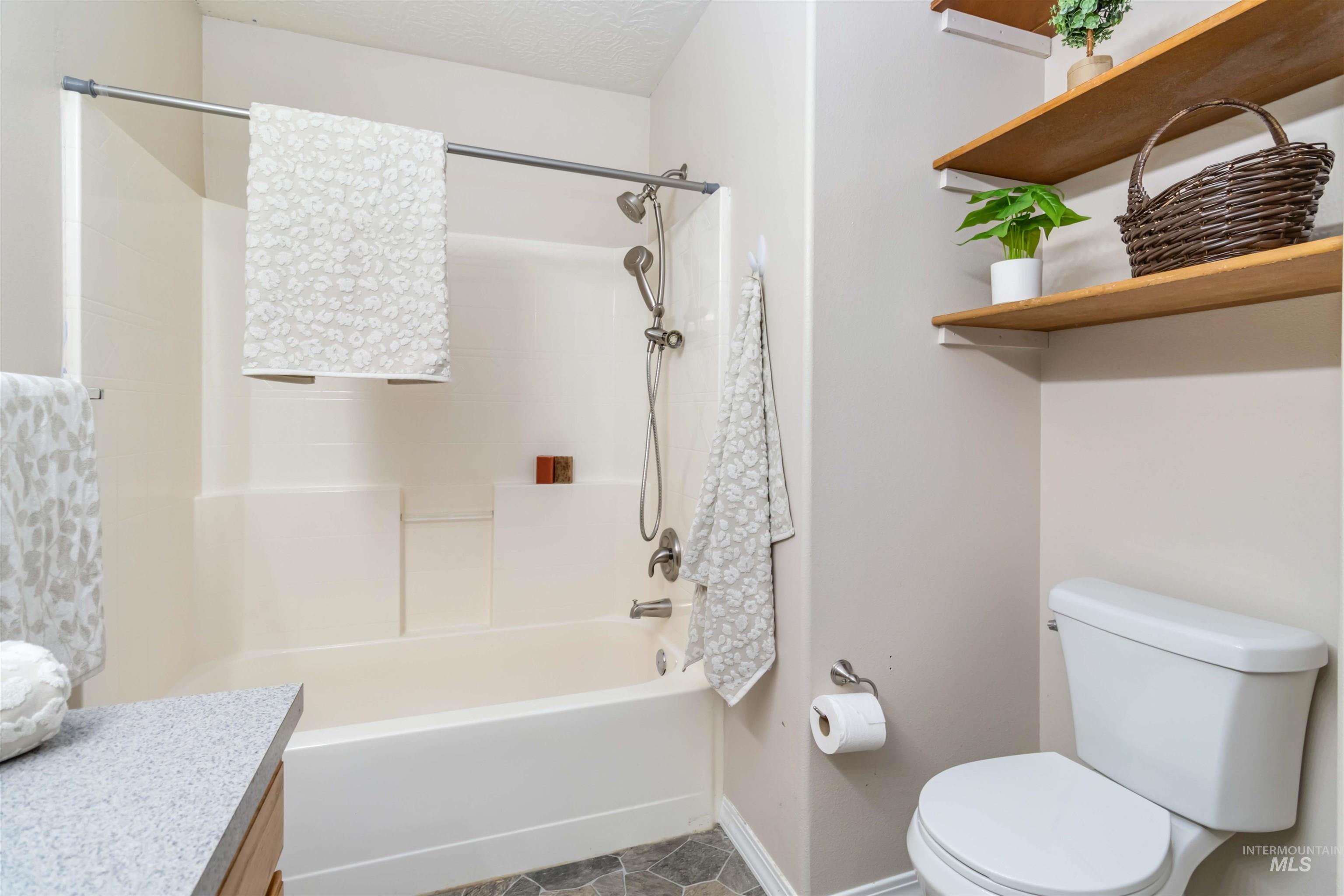 Full bathroom with shower / bath combination, vanity, and a textured ceiling