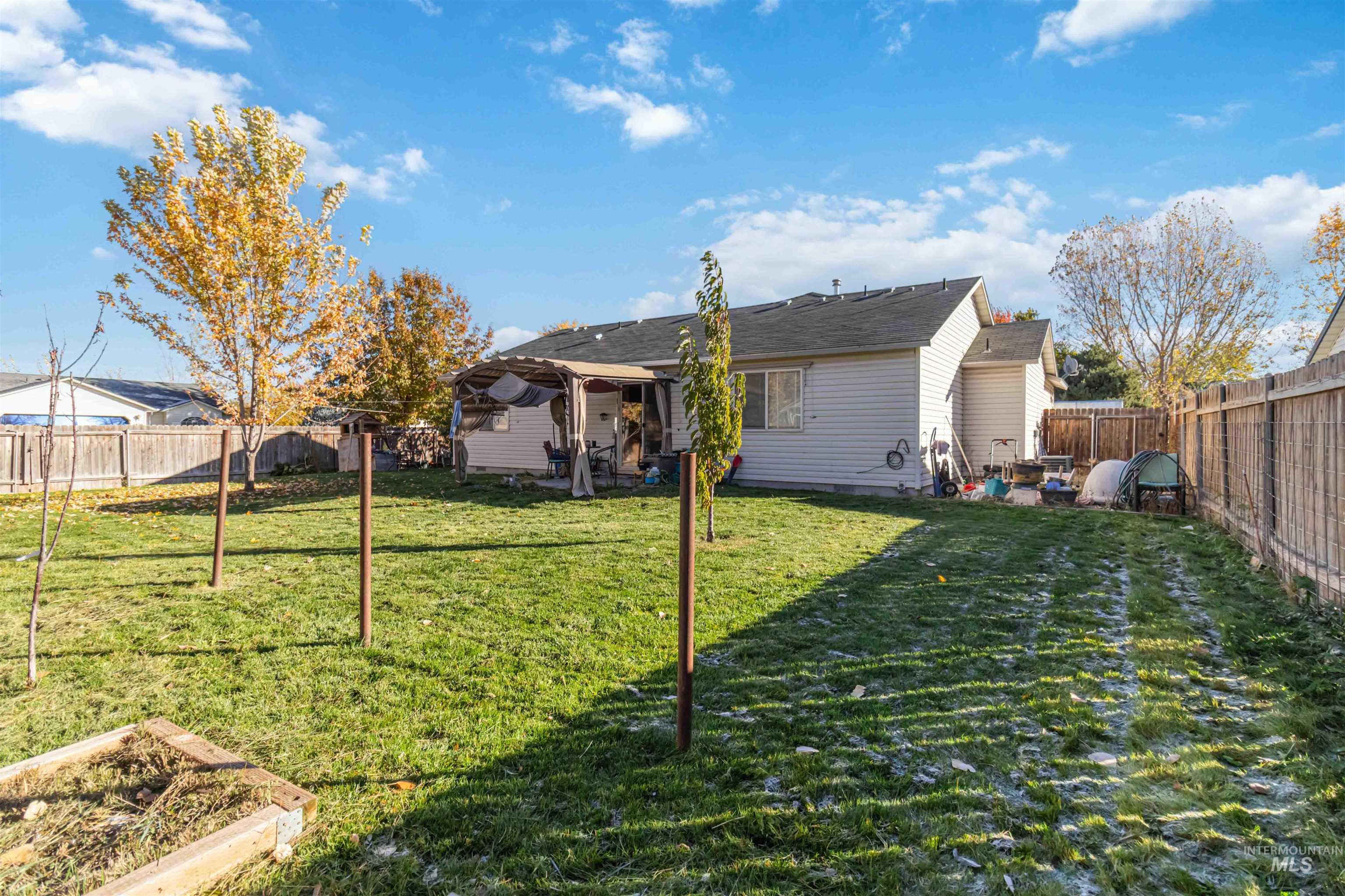 Back of property featuring a fenced backyard and a patio