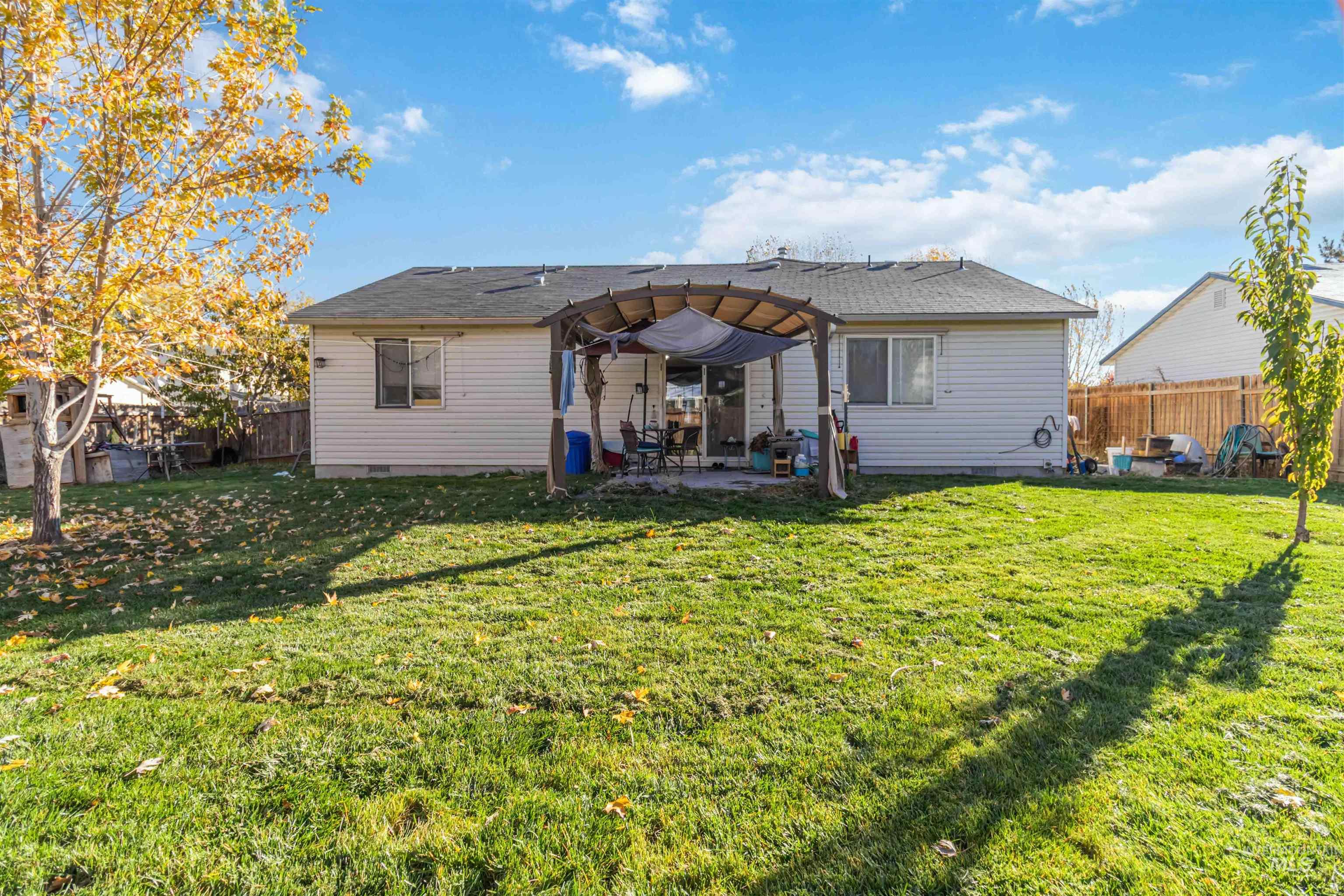 Rear view of house featuring crawl space, a patio area, a fenced backyard, and roof with shingles