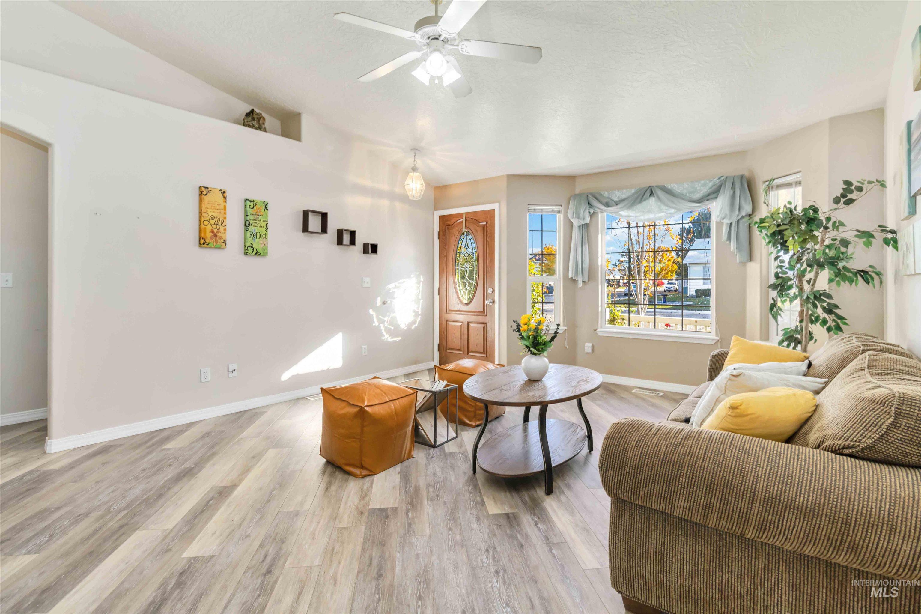 Sitting room with wood finished floors, ceiling fan, and lofted ceiling