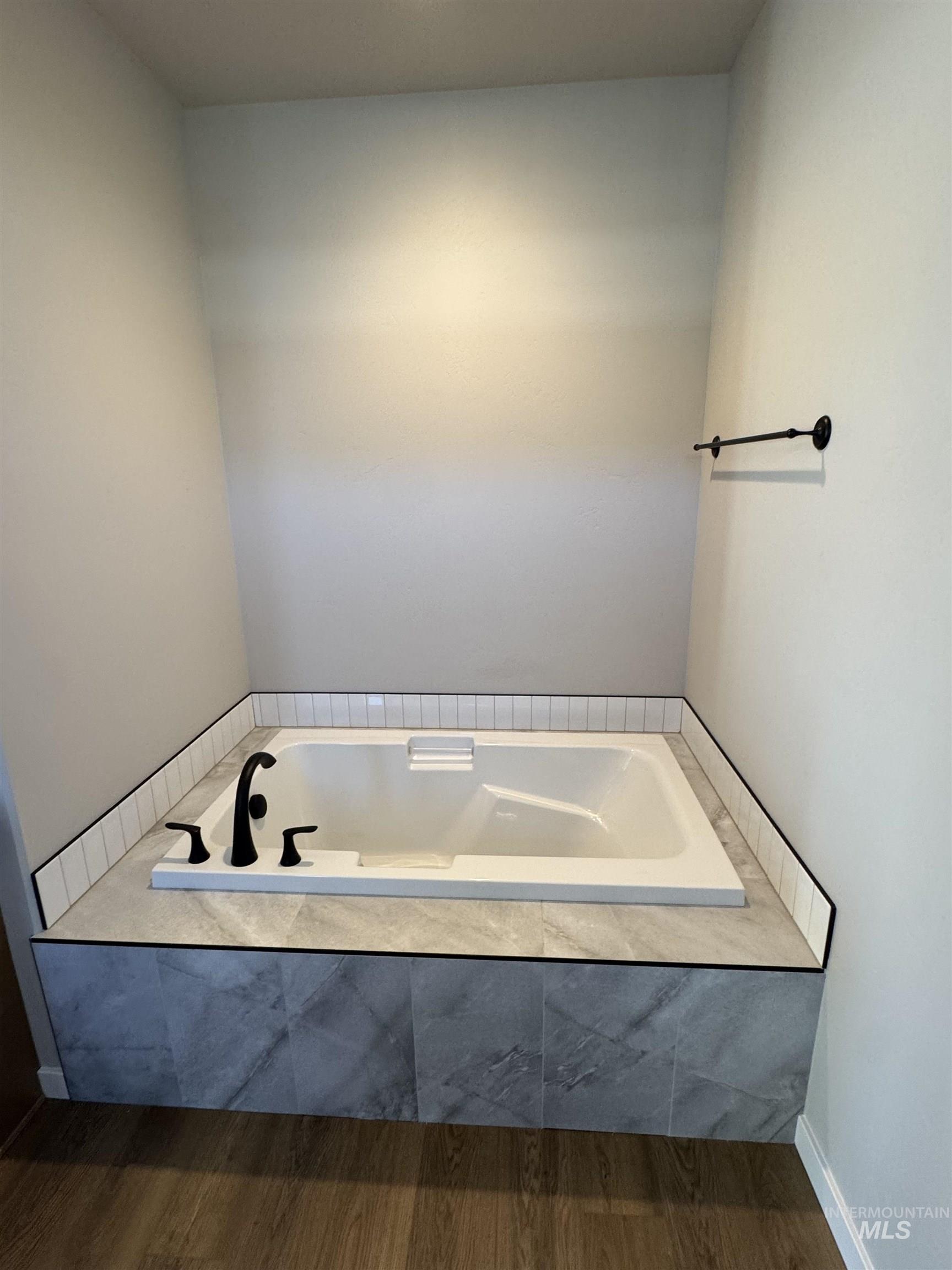 Bathroom with a bath and wood finished floors