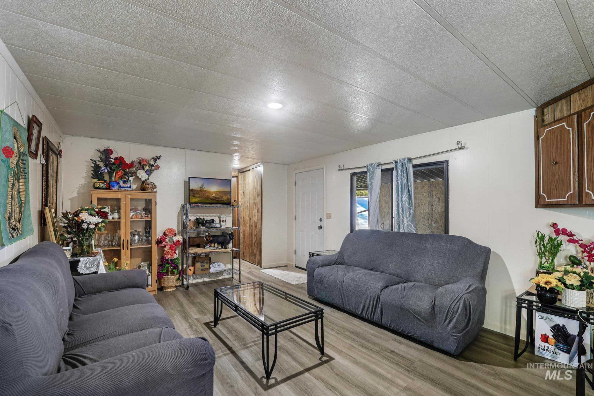 Living room featuring a textured ceiling and light wood finished floors