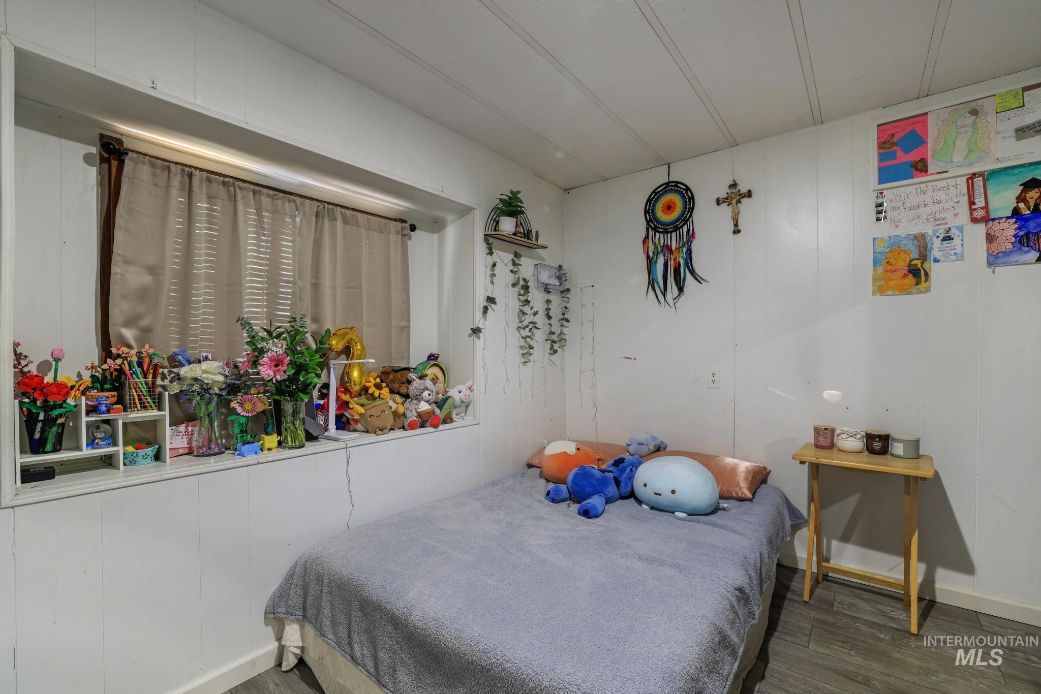 Bedroom with wood finished floors and wood walls