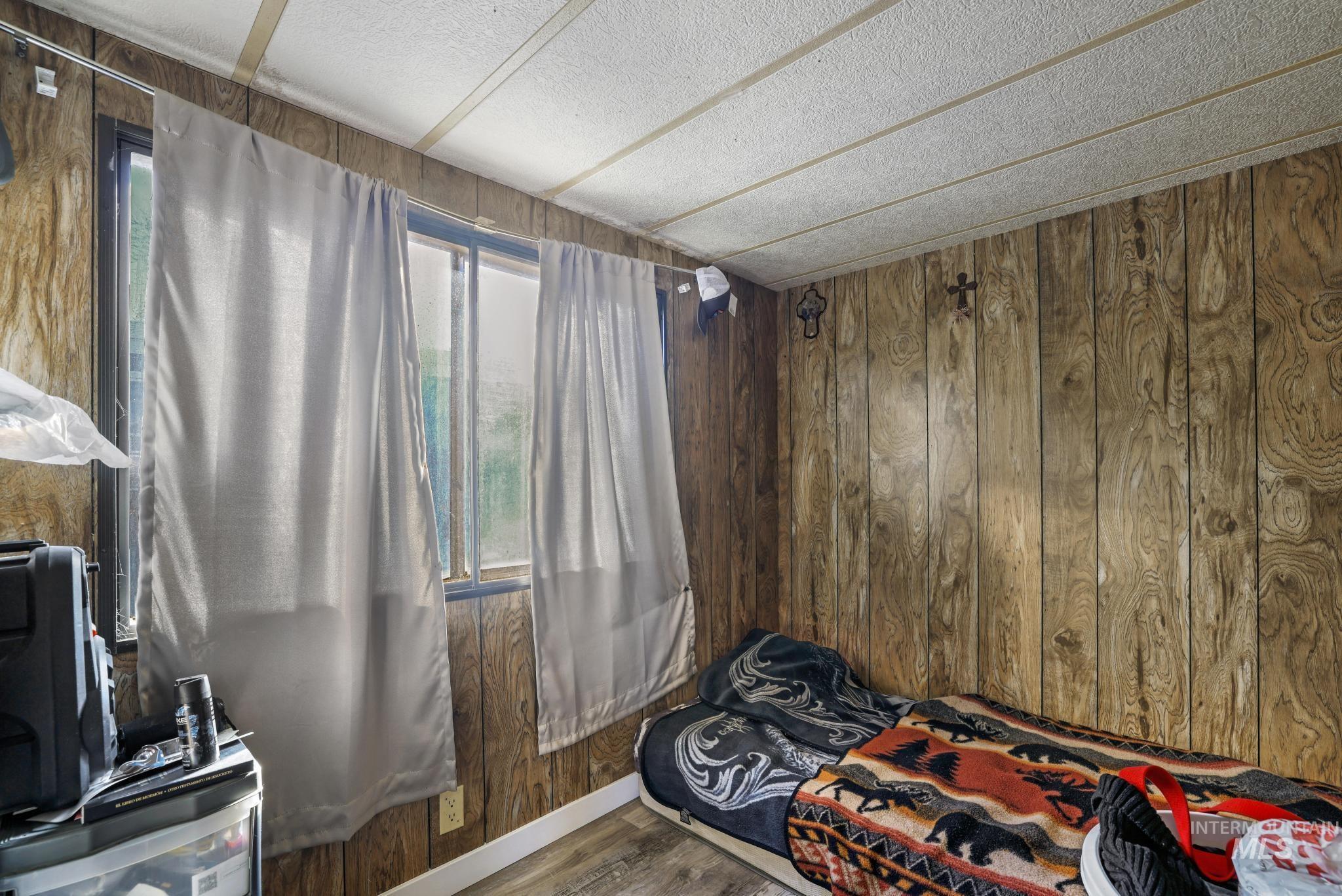 Bedroom with wooden walls and wood finished floors