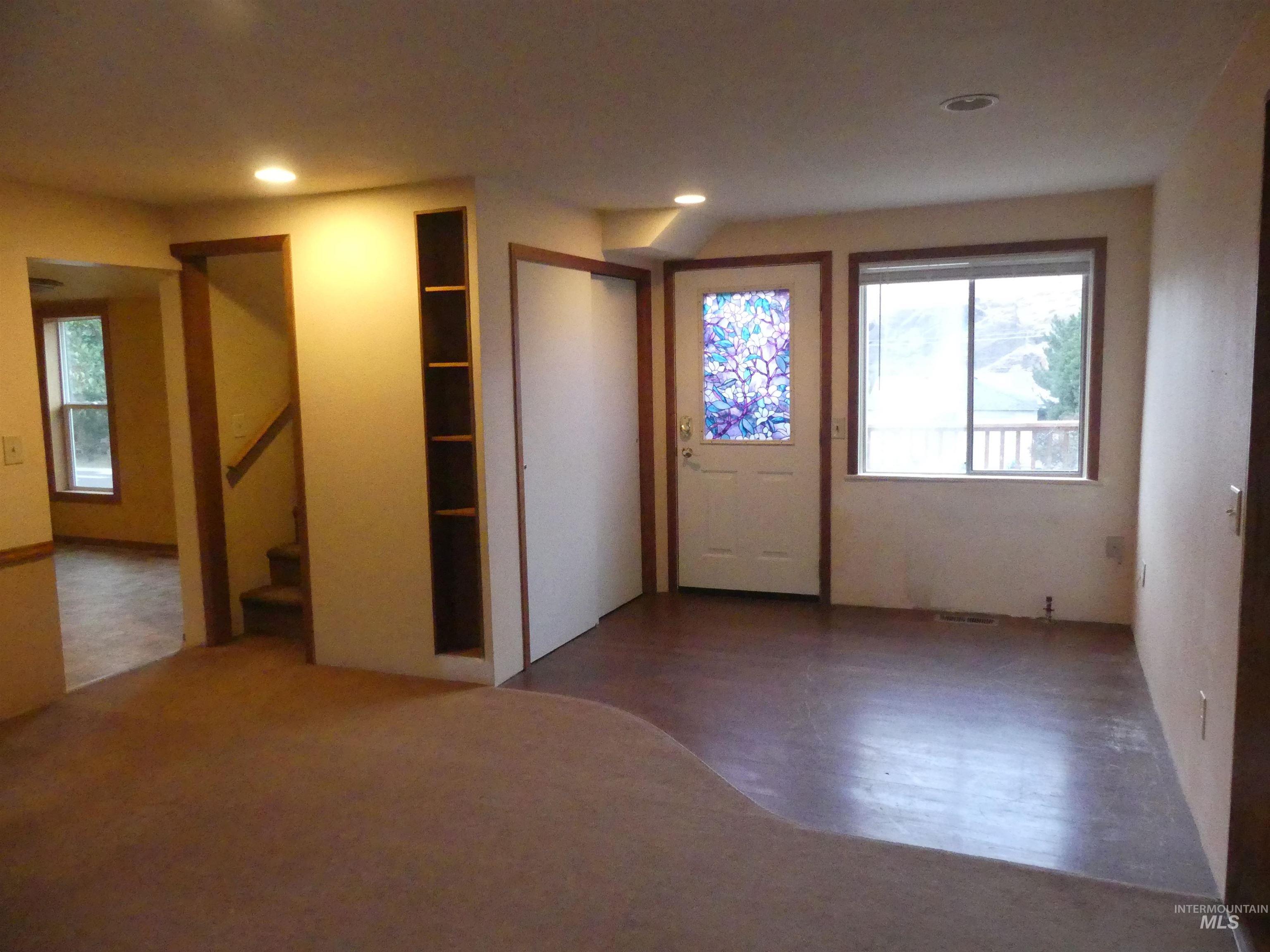 Foyer with wood finished floors, stairs, and recessed lighting