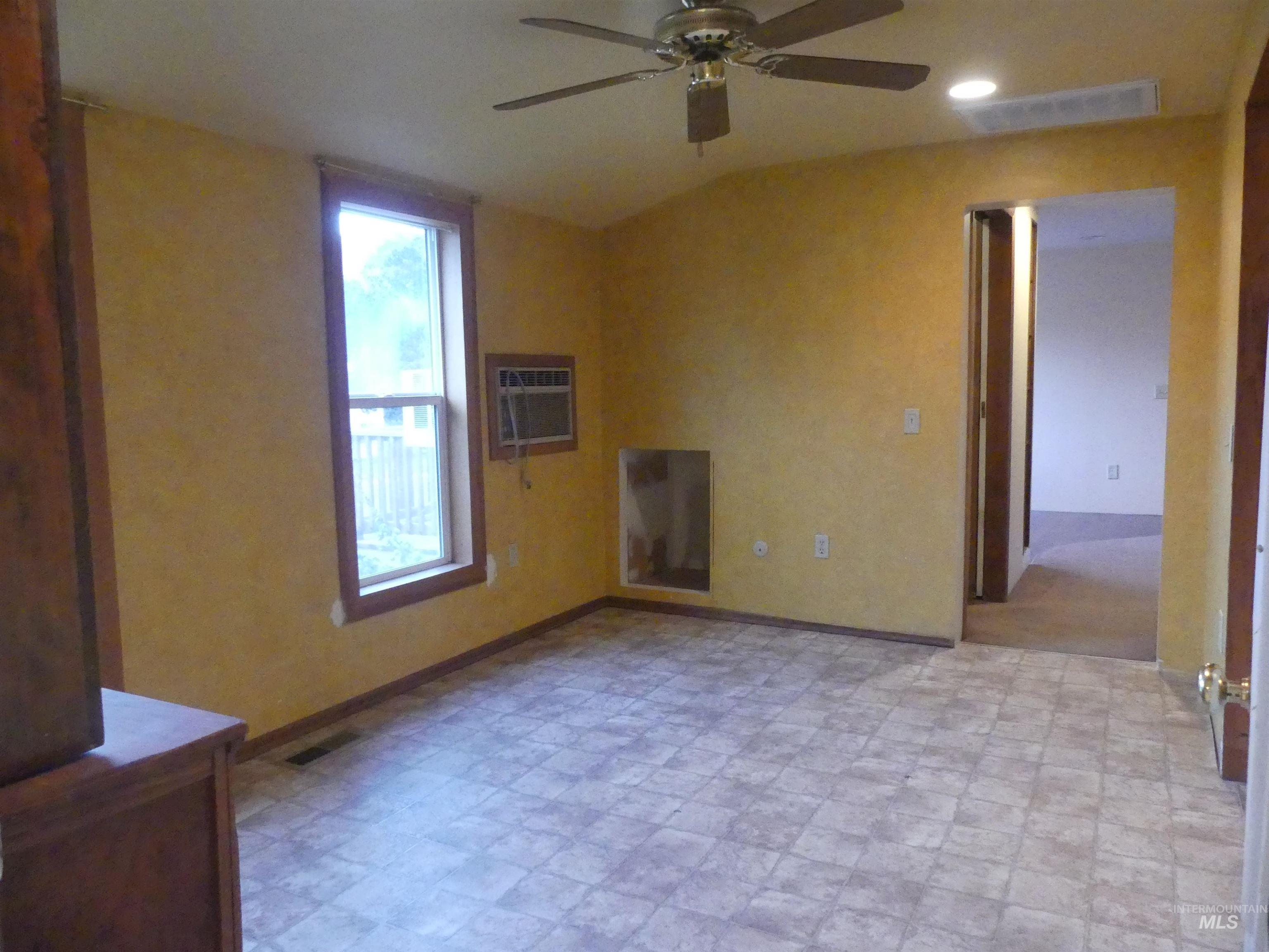 Unfurnished living room with ceiling fan, a wall mounted air conditioner, and recessed lighting