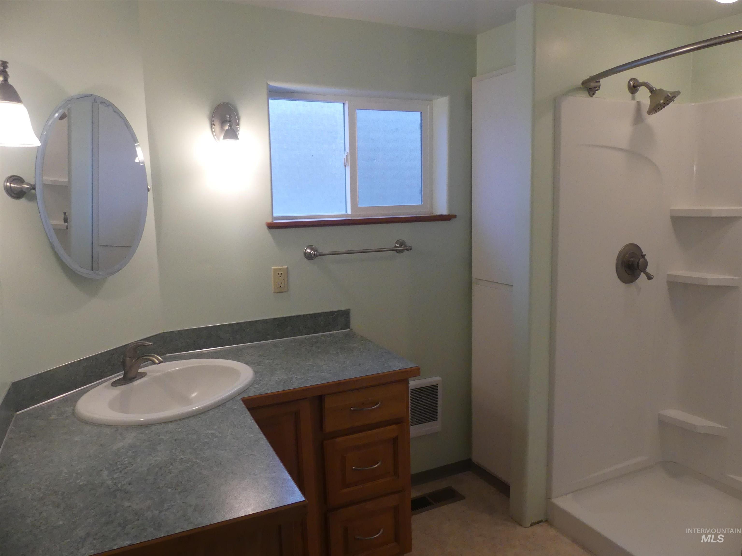 Full bath featuring vanity and a shower stall