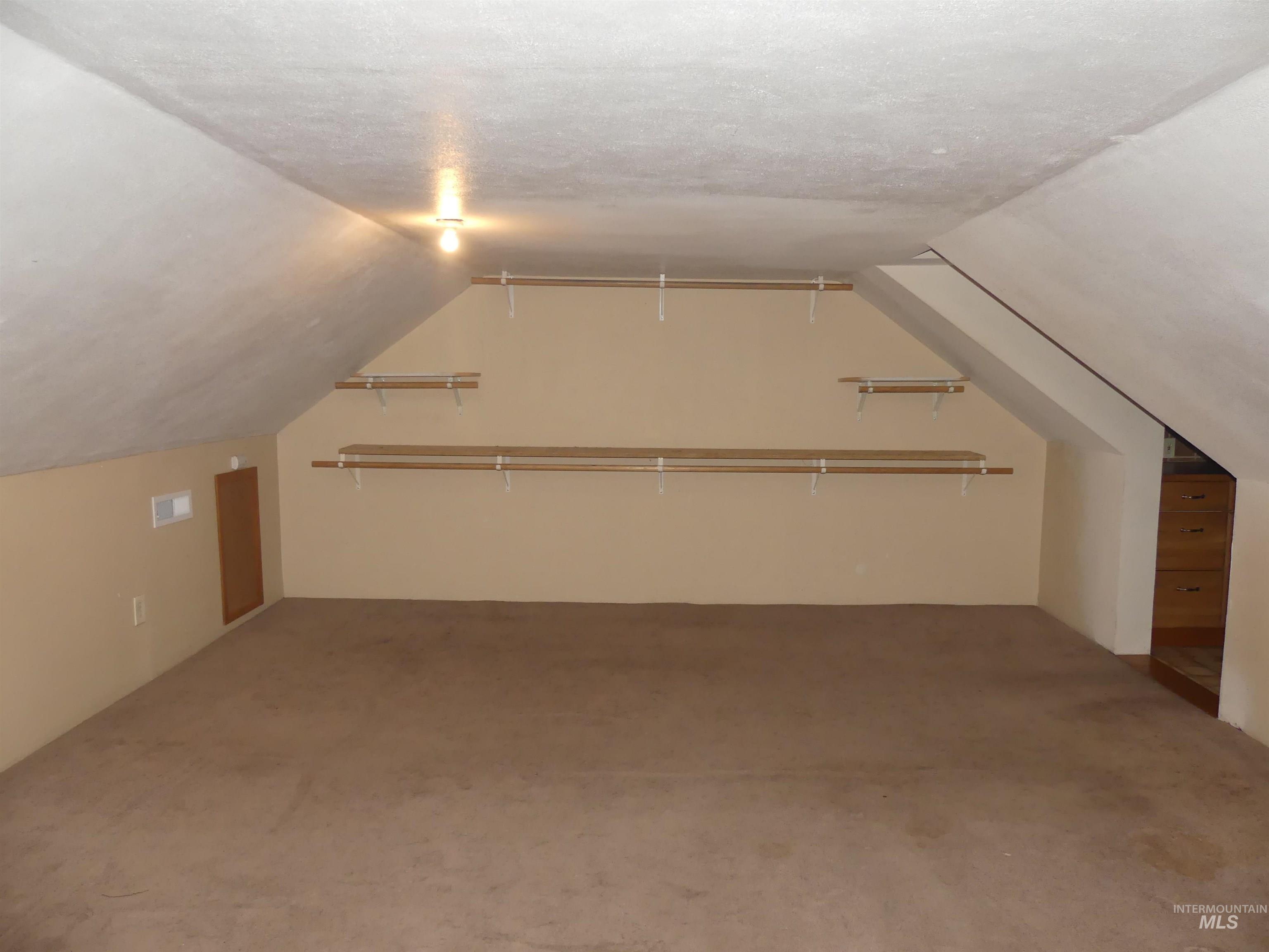 Bonus room featuring vaulted ceiling, carpet flooring, and a textured ceiling