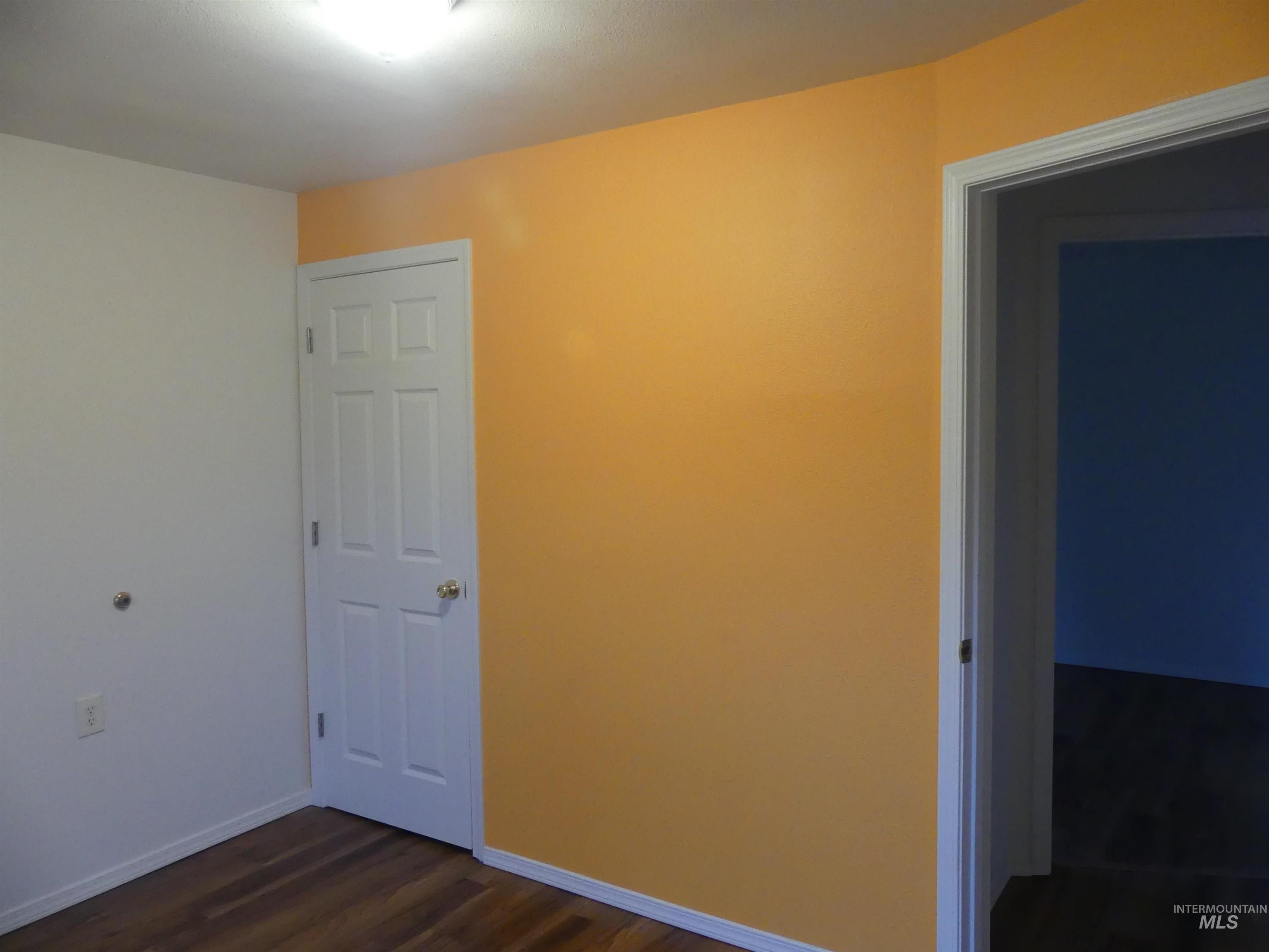 Spare room featuring dark wood finished floors and baseboards
