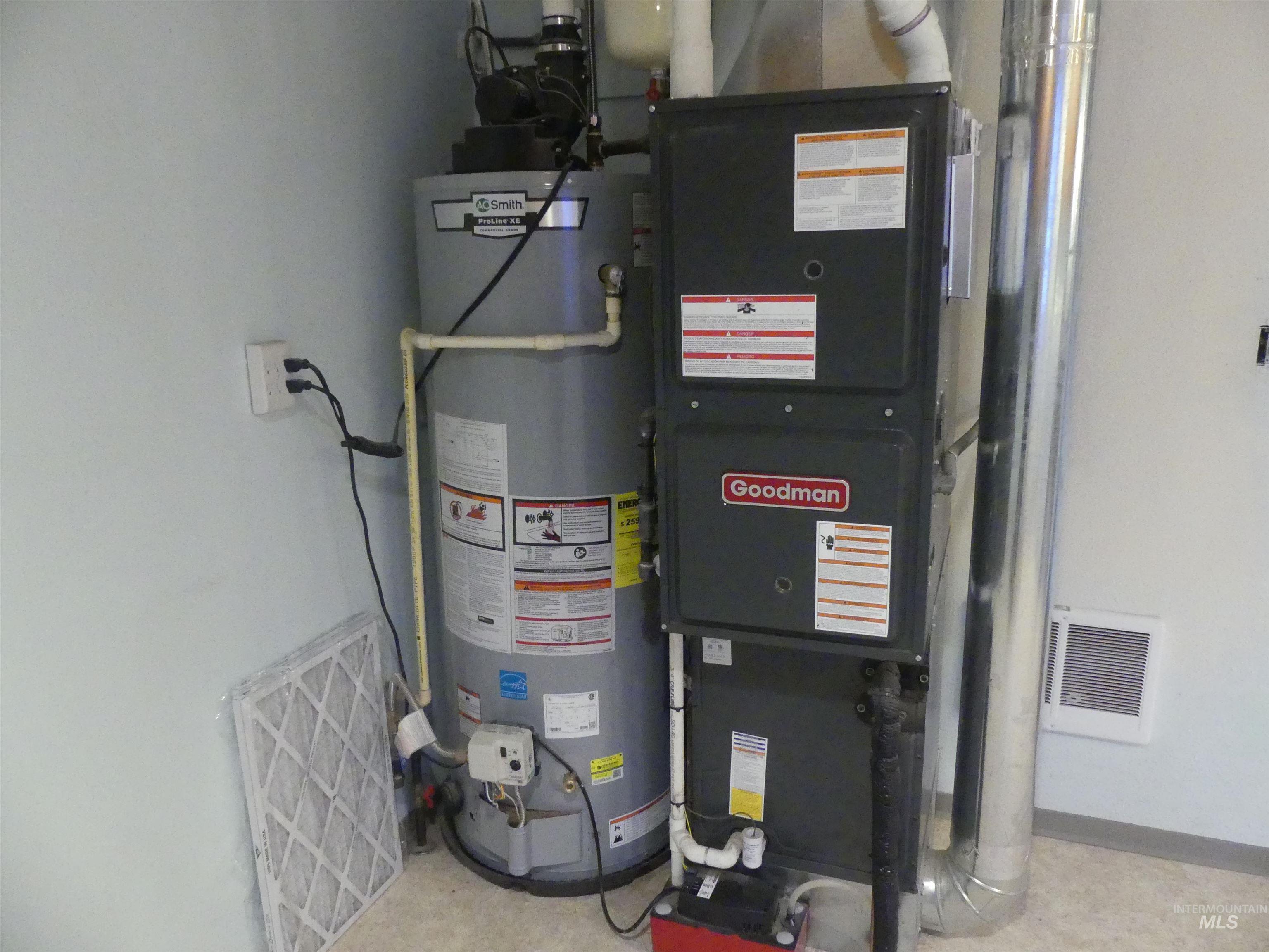 Utility room featuring water heater and heating unit