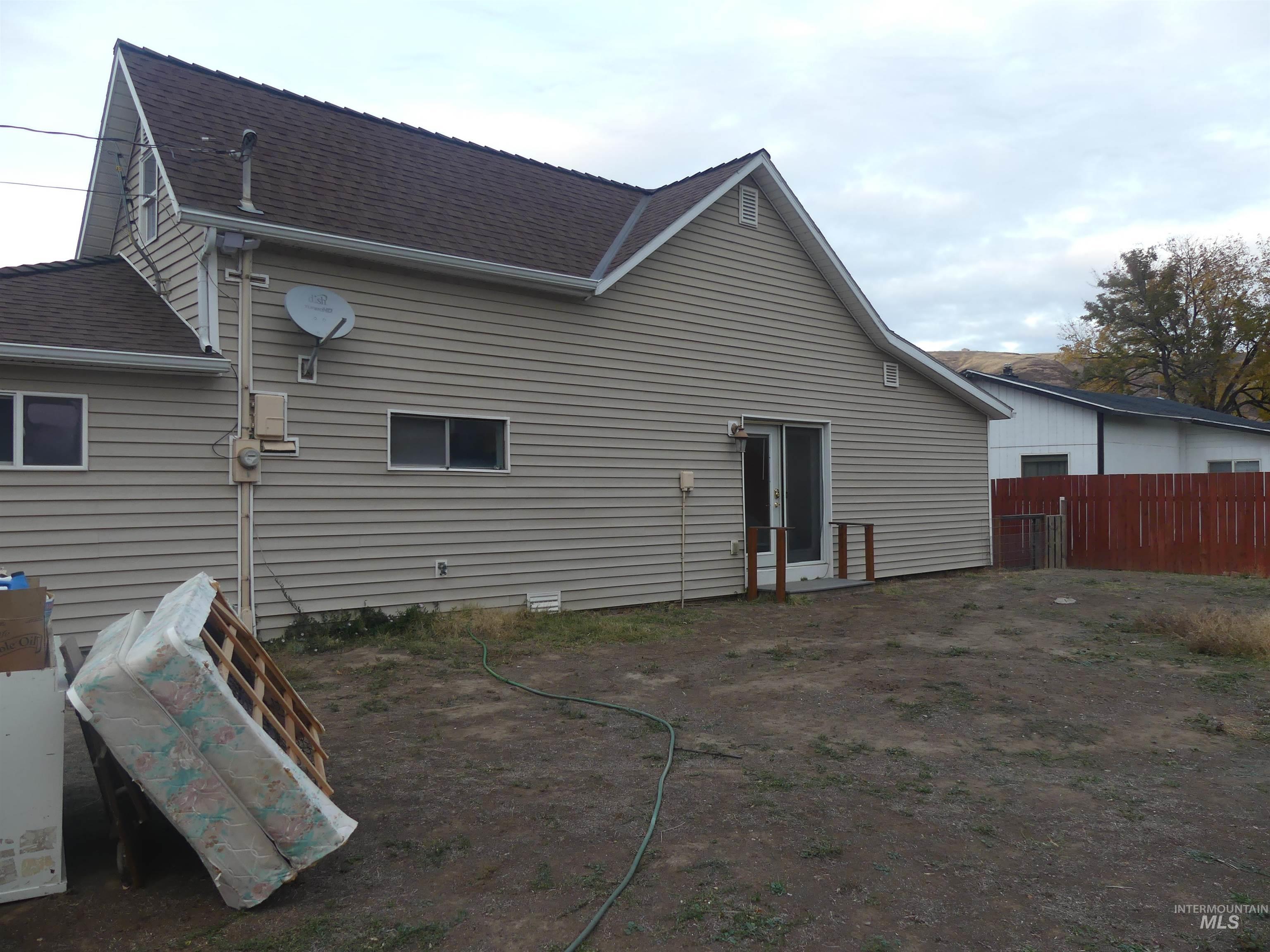 Rear view of house featuring a shingled roof