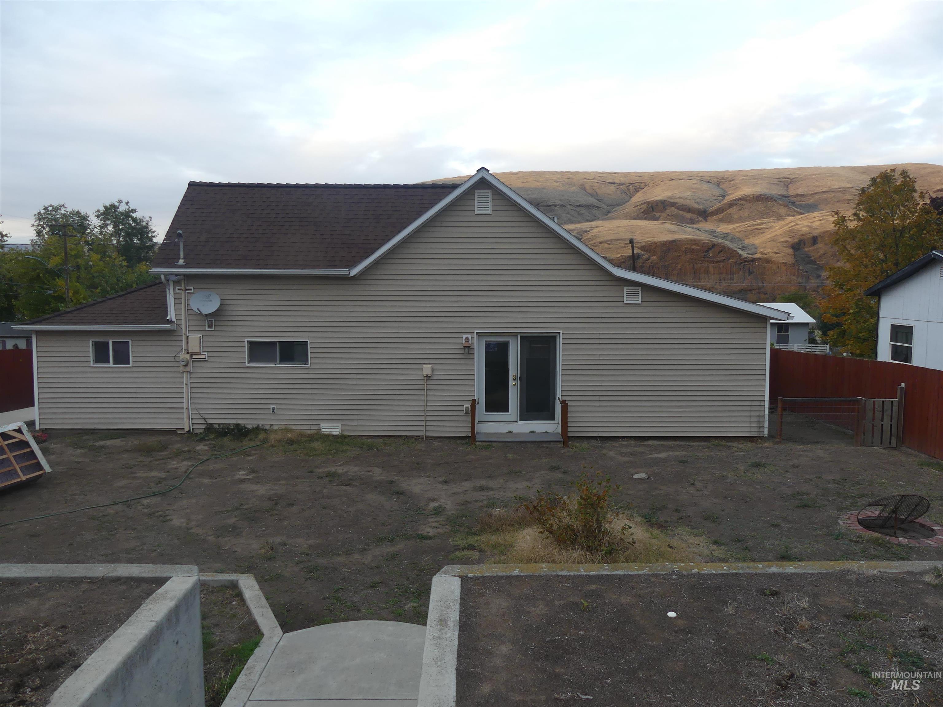 Back of property featuring french doors, a mountain view, and roof with shingles
